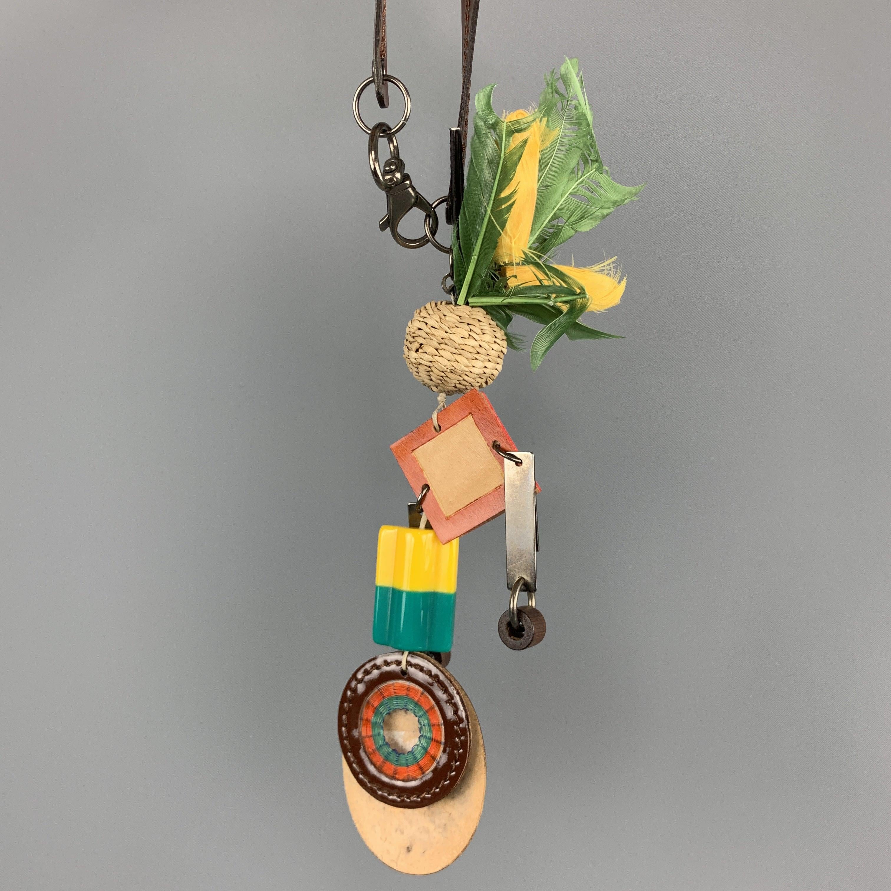 MARNI Key Ring Bag Charm comes in multi-color tones in mixed materials, with a brown patent leather strap, green feathers, straw, plastic and silver tone metal hardware, contrast stitching, and a lobster clasp closure. With dust bag and