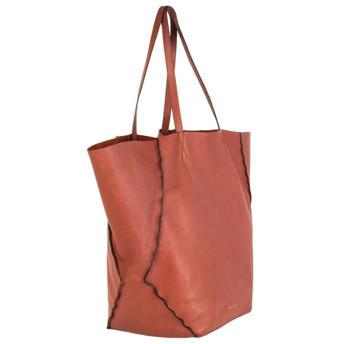 100% authentic Marni hobo tote shoulder bag in rust lambskin and black painted edges. Unlined. Comes with a detachable zipper leather pouch. Has been worn with some soft pen-marks on the inside bottom. Overall in very good condition.