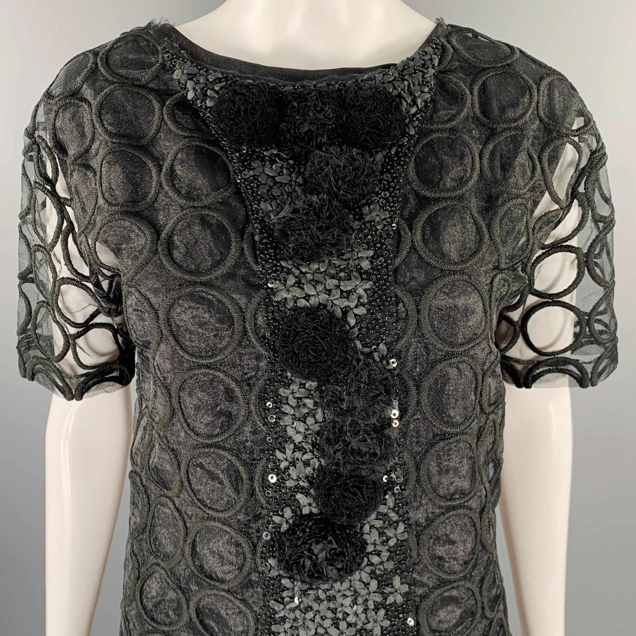 Robe Marni
en polyester noir, avec un design à double couche, une couche transparente avec des cercles, des manches courtes et des appliques à pompon sur le devant. Livré avec une housse. Fabriqué en Italie. Excellent état. 

Marqué :   IT 40