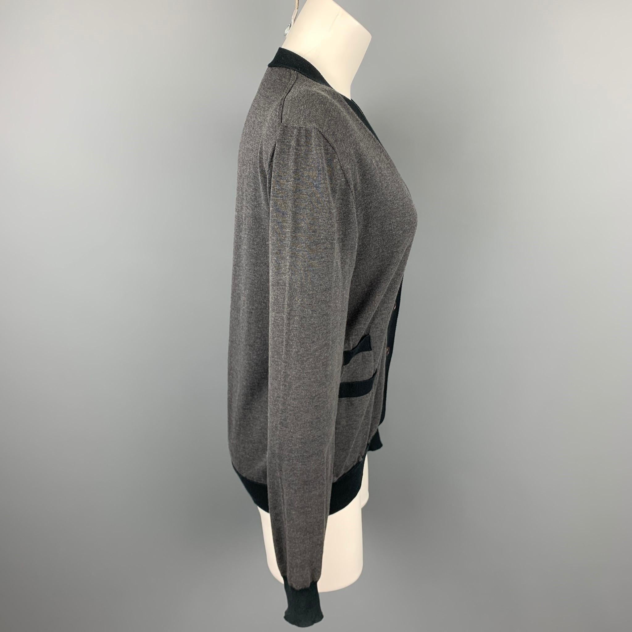 MARNI cardigan comes in a grey jersey cotton with a navy trim featuring a v-neck, front pockets, and a buttoned closure. Made in Spain.

Good Pre-Owned Condition.
Marked: 42

Measurements:

Shoulder: 17 in. 
Bust: 38 in. 
Sleeve: 27 in. 
Length: