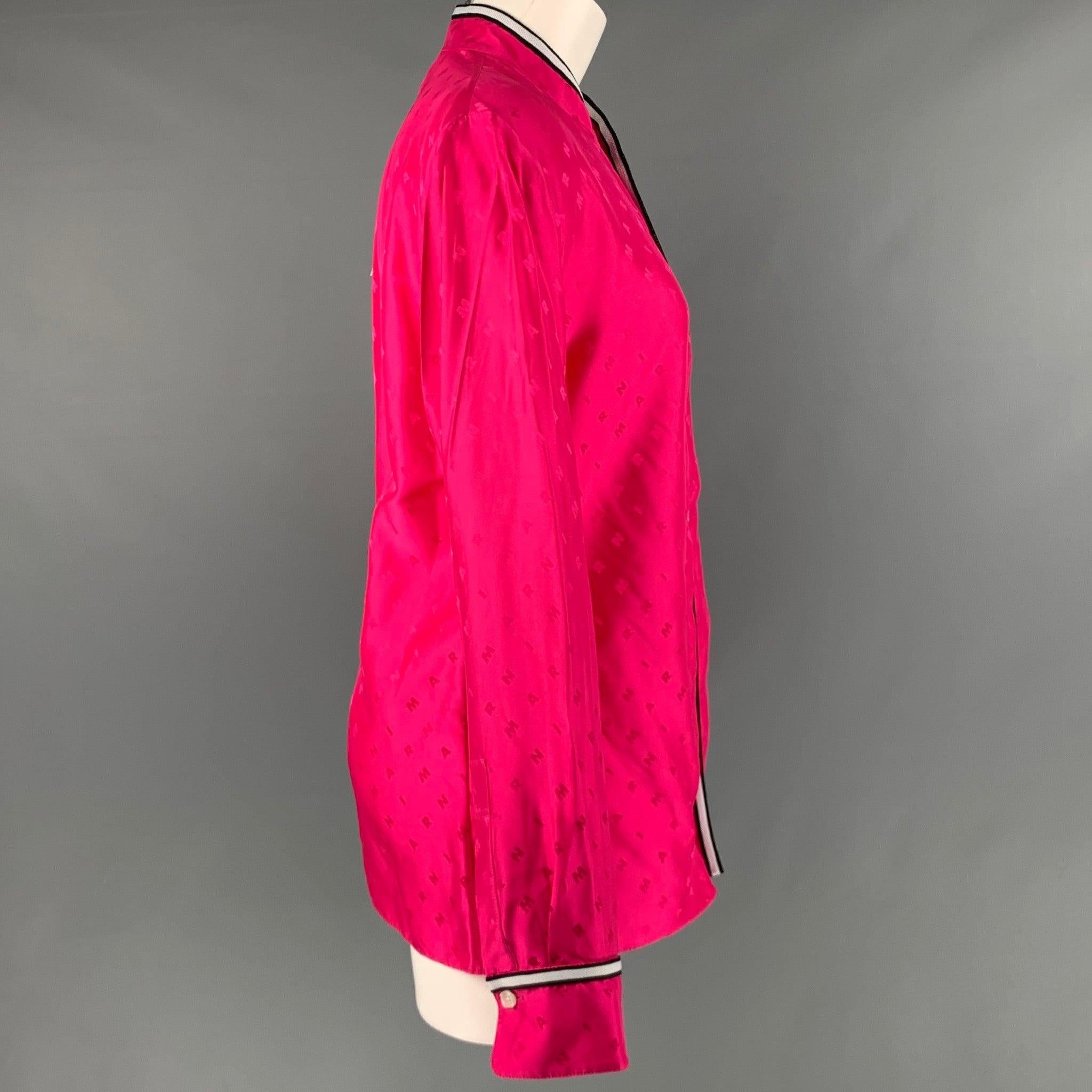 MARNI Langarmhemd
aus rosafarbenem Viskosestoff mit Marni-Monogramm-Muster, Nehru-Kragen mit schwarz-weißem Kontrastbesatz, einer kleinen Tasche und Knopfverschluss. Hergestellt in Italien &New with Tags. 

Markiert:   44 

Abmessungen: 

