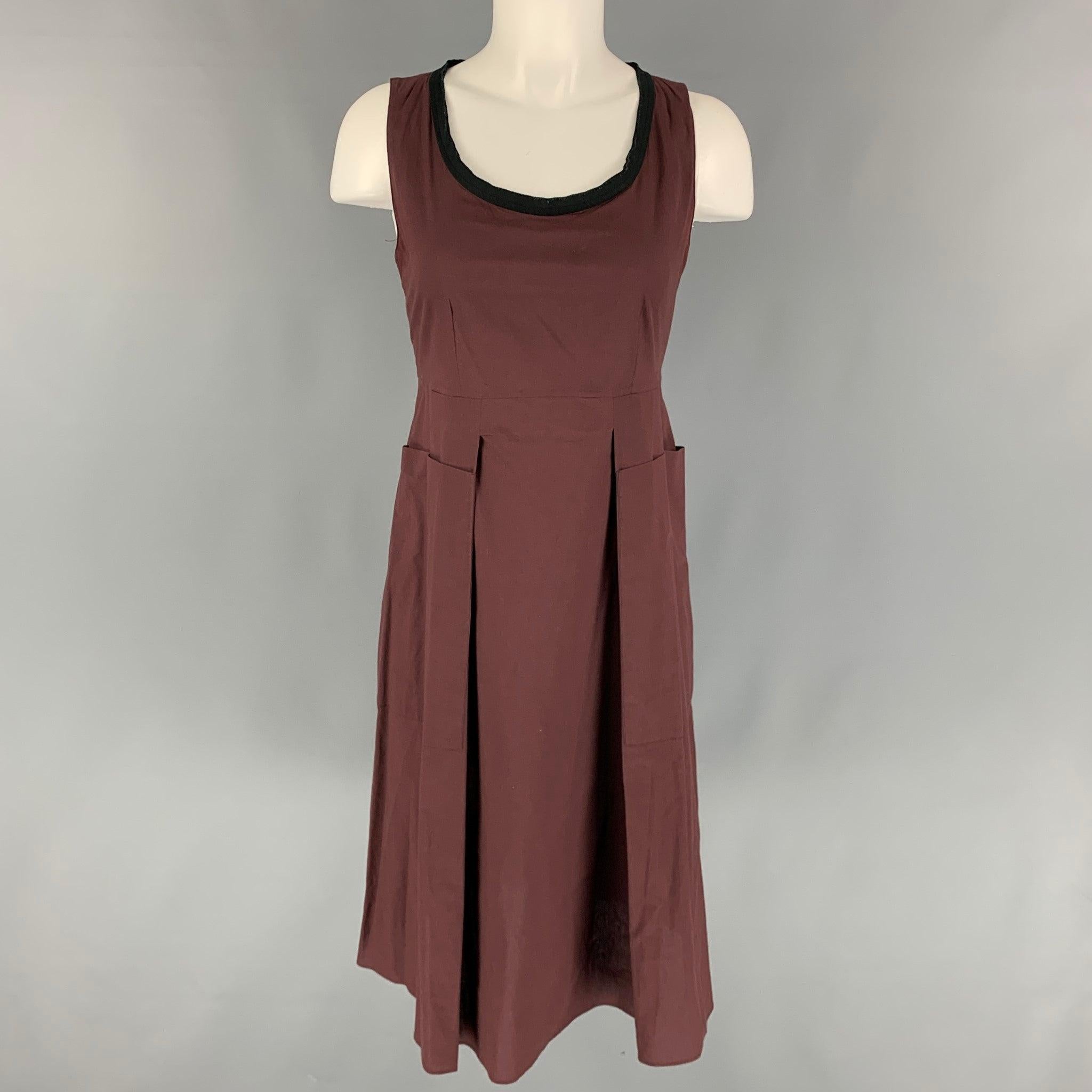 MARNI SS 13 2 Piece dress set comes in a burgundy cotton featuring a sleeveless style, black trim, pleated, front pockets, back zip up closure, and a matching coat. Made in Portugal.
Very Good
Pre-Owned Condition. 

Marked:   40 

Measurements: 
 