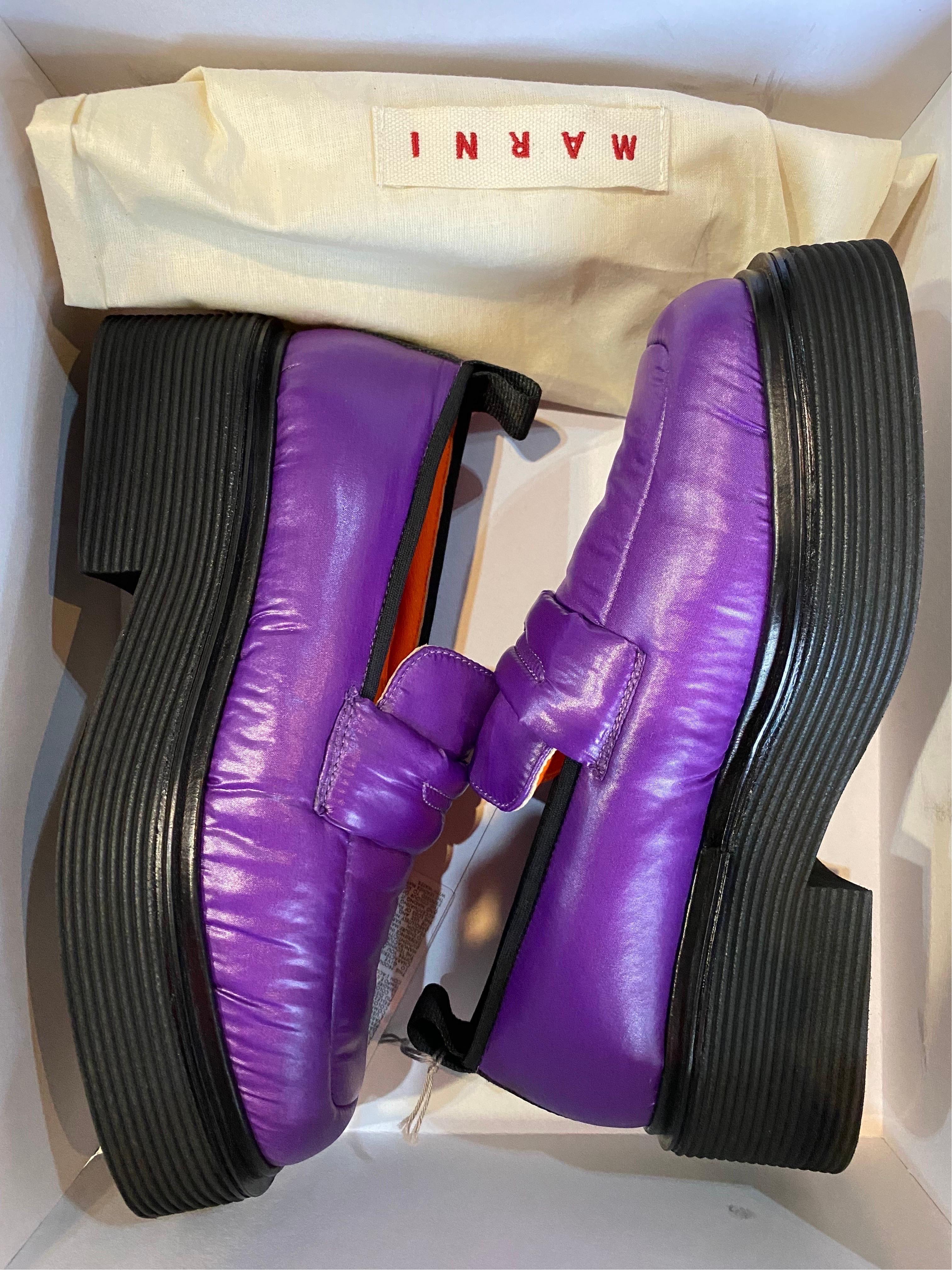 MARNI LOAFERS.
In purple technical fabric.
Orange leather interior. Rubber heel.
Number 37
Inner sole 23.5 cm
Heel 5 cm
Plateau 3 cm
New with box. Never worn.
Has a small flaw on the heel of the left shoe as shown in the photo.