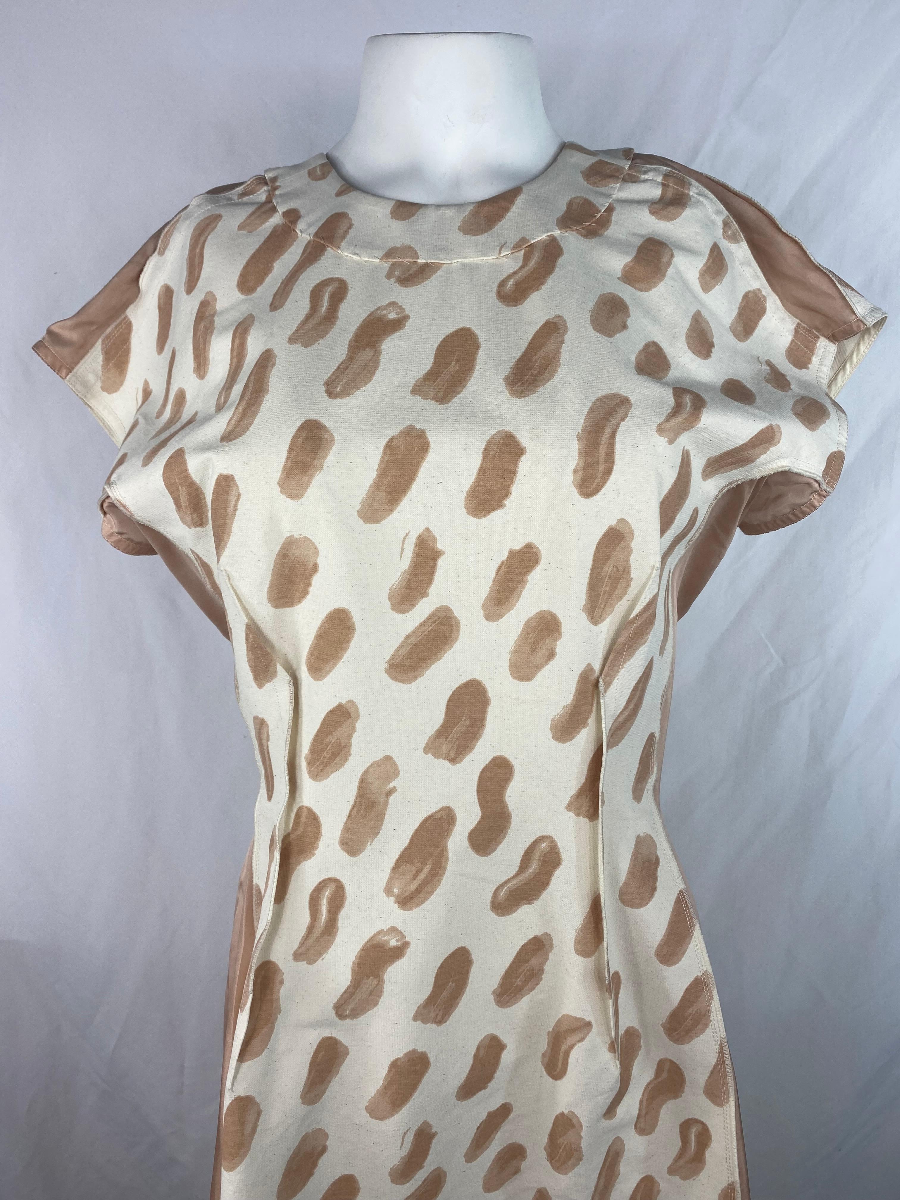 Product details:

The dress features white, cream and beige colors with abstract brush stork print, crew neck line folded bottom detail and rear silver tone zip closure.