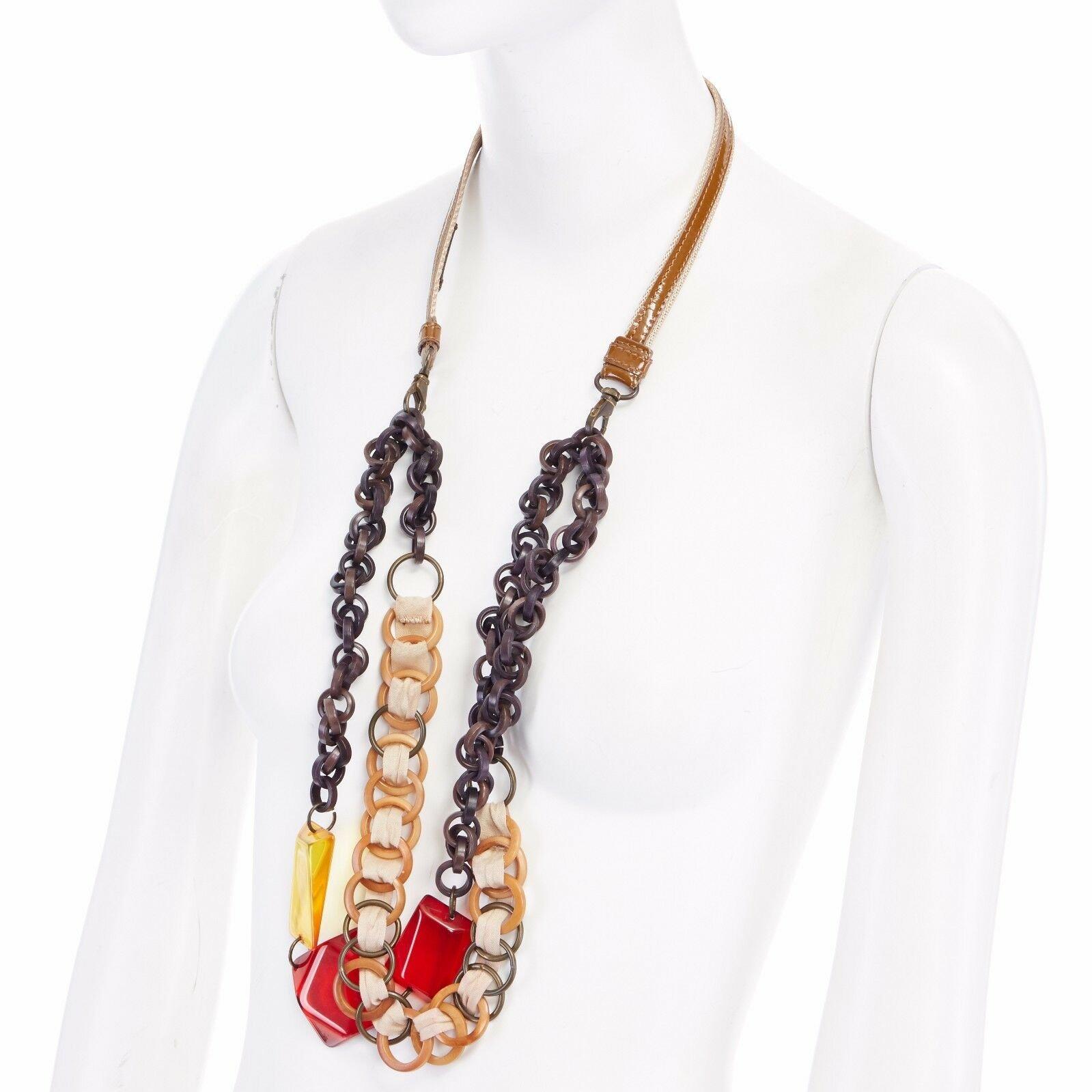 MARNI wood resin dual chunky interlinked red orange pendent nylon necklace 
Reference: TGAS/A01098 
Brand: Marni 
Material: Resin 
Color: Brown 
Extra Detail: Brown, ivory resin with canvas string interlink. Red and yellow angular cut clear resin