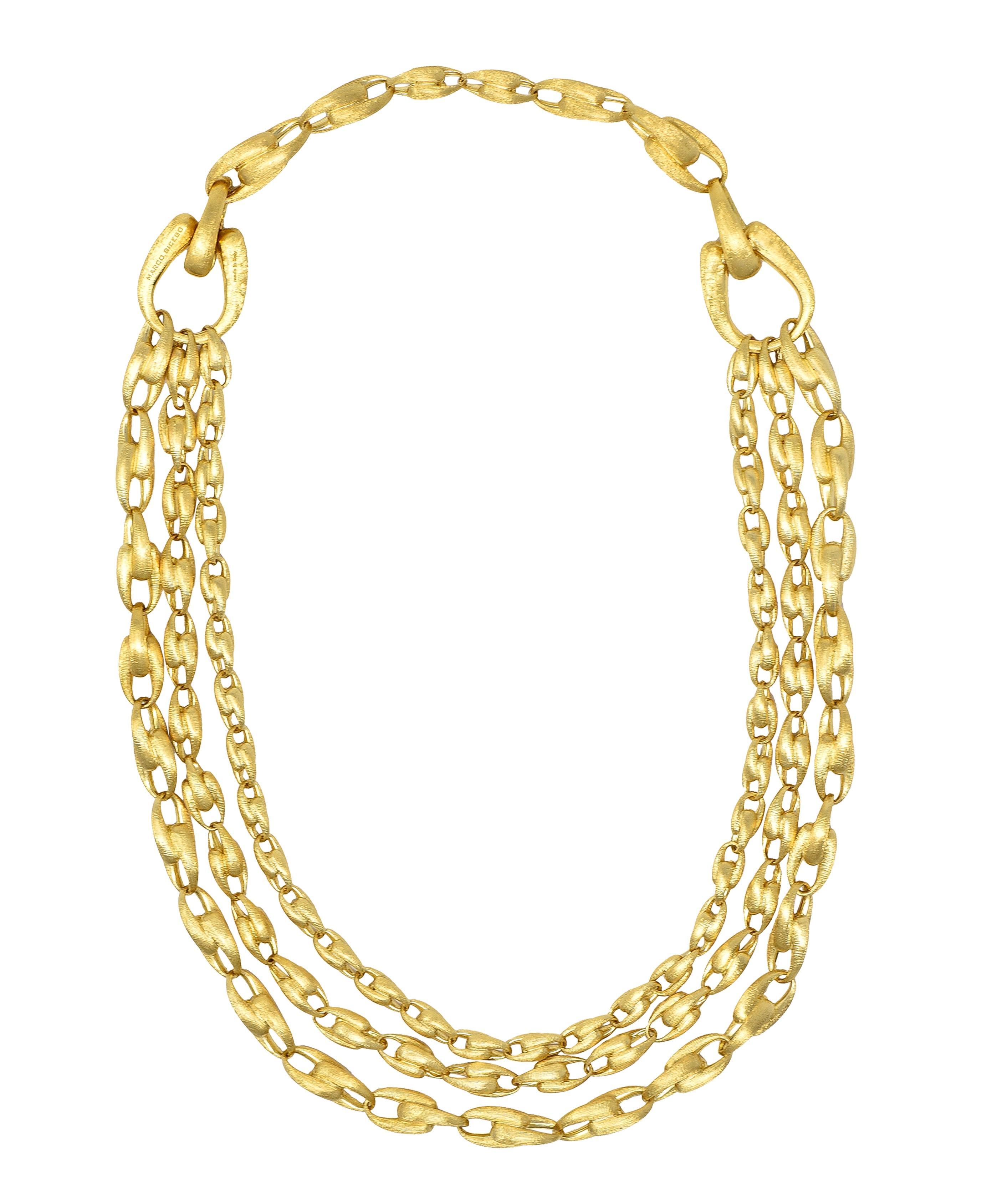 Comprised of tiered strands of graduated U-link chain with brushed gold texture throughout
Suspending from single chain and gathered at large U link stations 
Completed by hinged clasp closure
Stamped with Italian assay marks for 18 karat gold
Fully