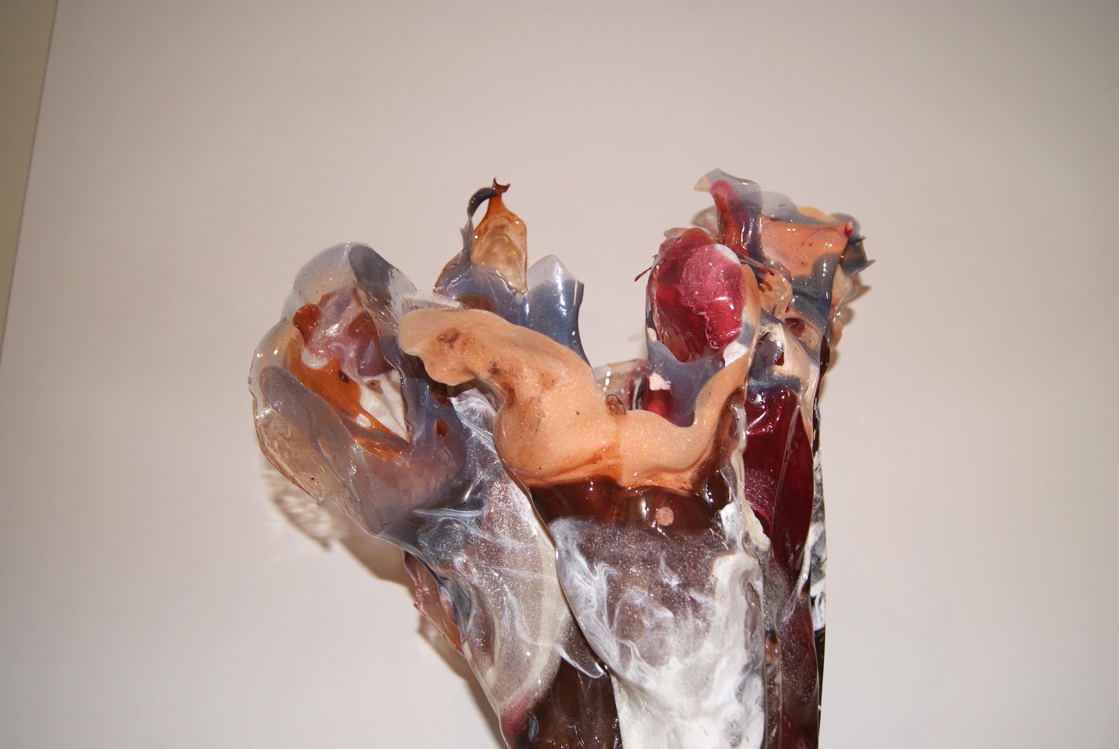 Sculptural resin vase in shades of reds, creams, and touches of blues.