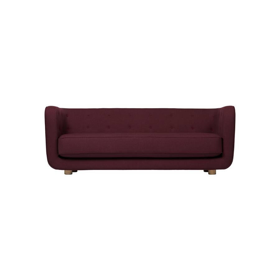 Maroon and Natural Oak Raf Simons Vidar 3 Vilhelm sofa by Lassen
Dimensions: W 217 x D 88 x H 80 cm 
Materials: Textile, Oak.

Vilhelm is a beautiful padded three-seater sofa designed by Flemming Lassen in 1935. A sofa must be able to function
