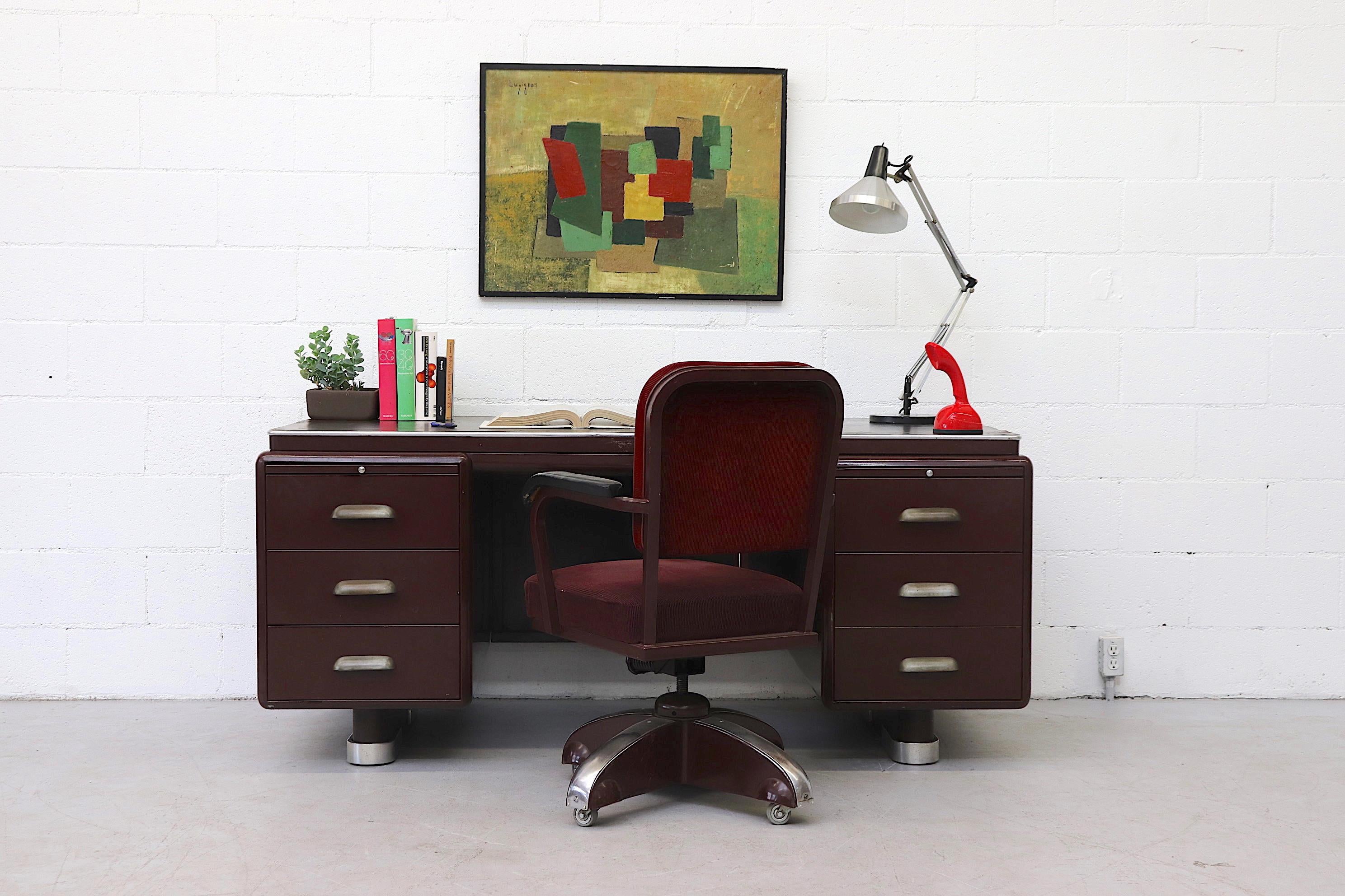Rare handsome Ahrend ODA executive desk in very original condition with visible wear and some denting. Charcoal linoleum top with maroon enameled metal casing. This rare version has linear cupped metal drawer pulls and 2 pullout / pull-out work