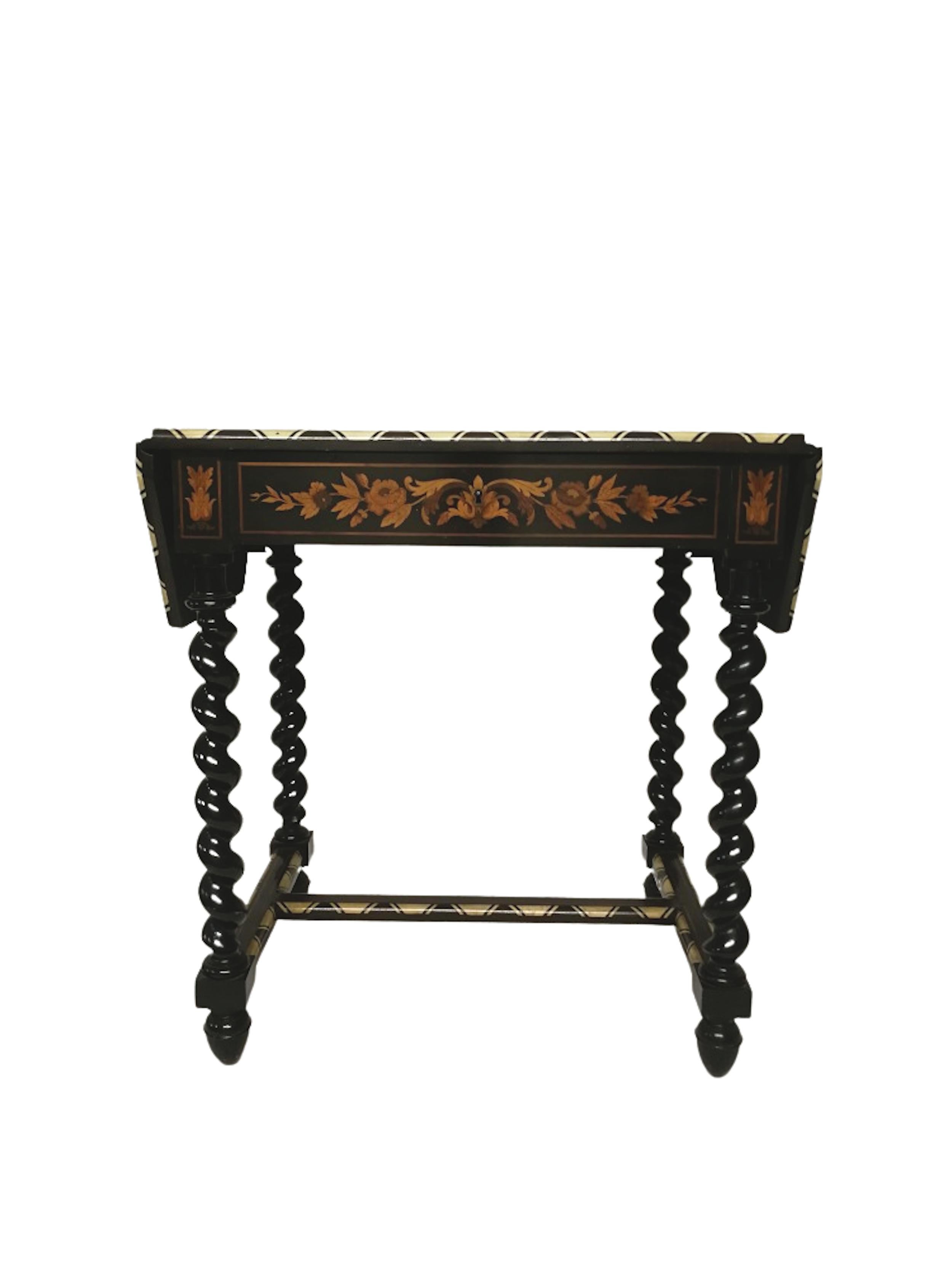 A Napoleon III period Louis XIII style marquetry table.
Floral marquetry table in veneer of various exotic woods, ebony, sycamore, blackened pear and
bone inlays, with fold down panels on both sides. Decorated with flowers, bows, ribbons,