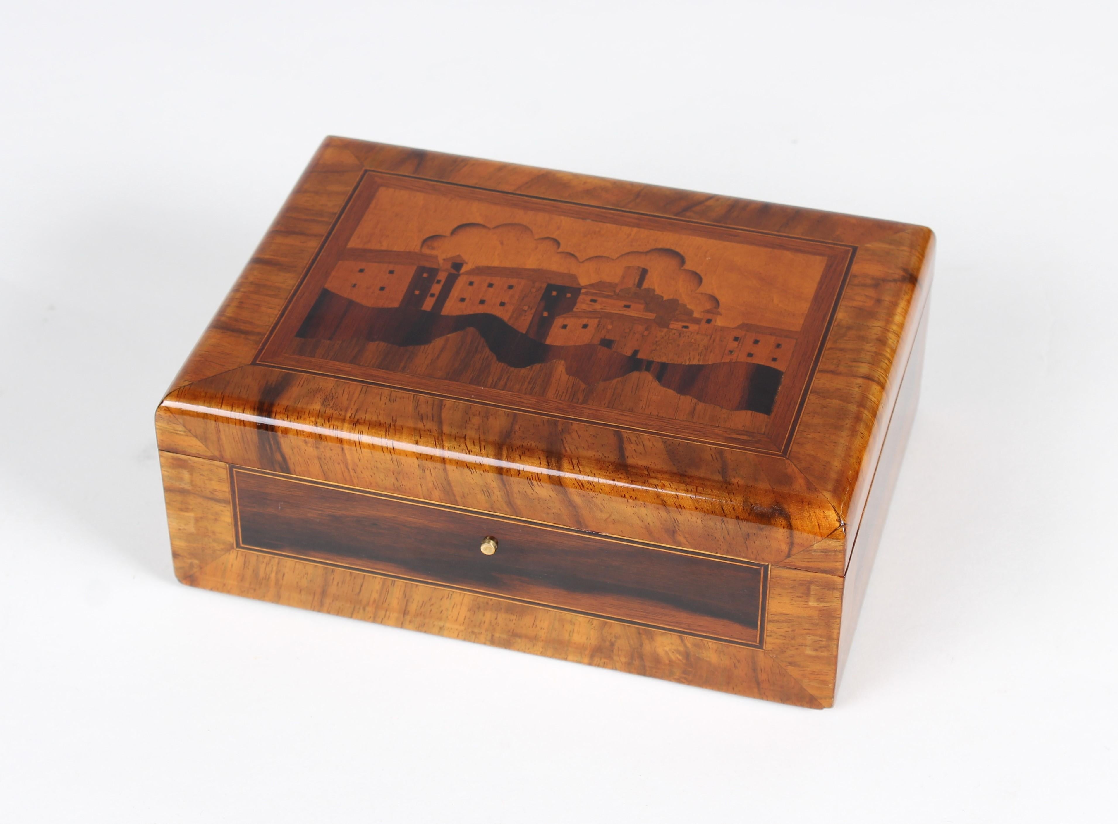 Small wooden box

Germany
Walnut and other precious woods
Middle of the 20th century.

dimensions: h x w x d: 7 x 19 x 14 cm

Description:
Small box with beautiful Marquetry. Inlayed is a scene of a coastal town.

Restored and shellac