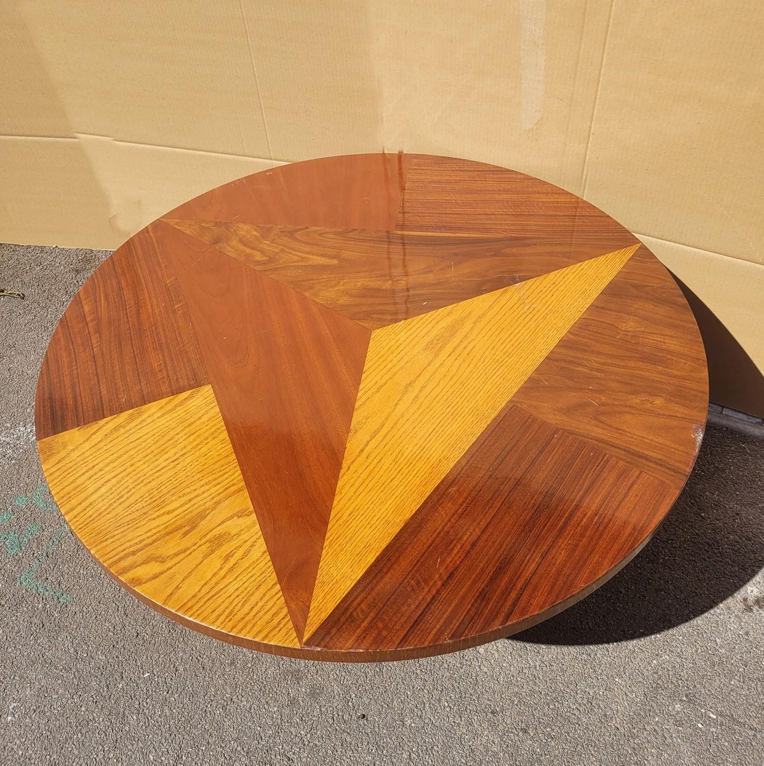Grande tavolino rotondo in legno intarsiato, con giochi di simmetria e colore, 4 gambe art déco con estremità in bronzo

Usuale usura della vernice

Altezza: 45 cm
Diametro 100 cm

