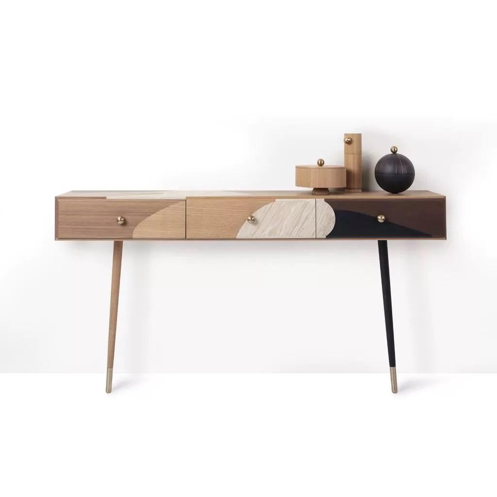 Consolle intarsiata di Thomas Dariel, Maison Dada.
Misure: L 160 x P 34 x H 110,8 cm.
Struttura in MDF rivestita con impiallacciature multiple verniciate.
Frontali in vernice opaca.
Gambe in metallo con impiallacciatura in frassino verniciato -