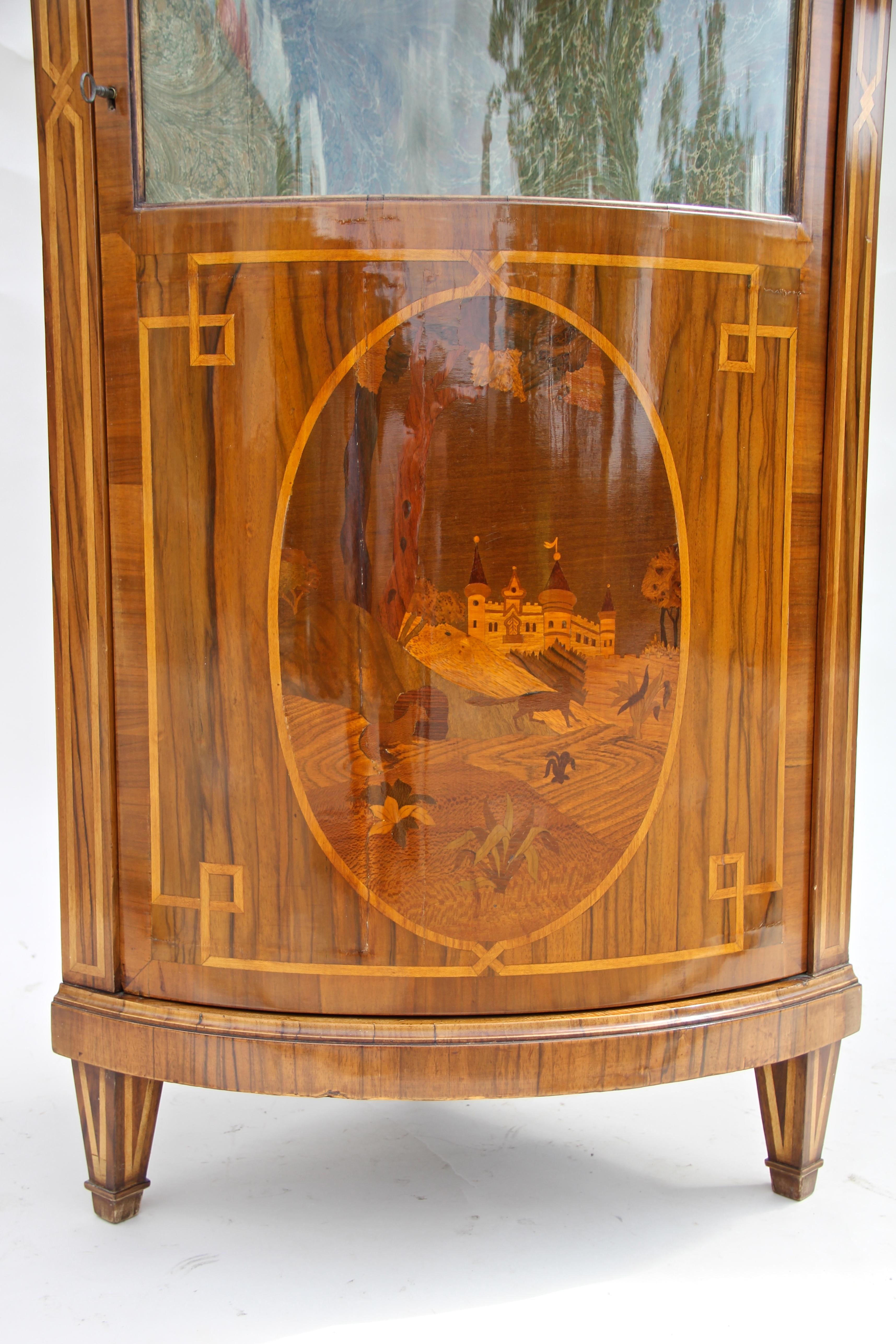 Fantastic Marquetry corner cabinet from the so-called Baroque Revival period circa 1890. This Austrian late 19th century vitrine cabinet shows a wonderful design with a unique curved shape. The front door provides a large curved glass panel, perfect