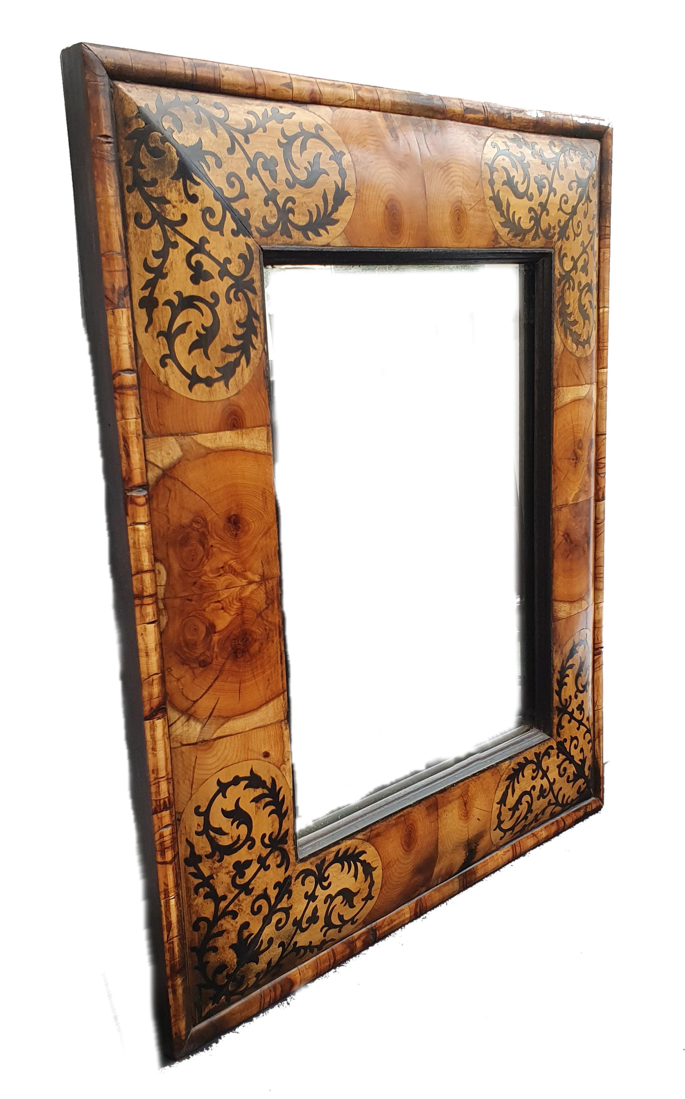 This beautiful marquetry cushion mirror features an intricate marquetry design of inlaid patterns. The mirror is a 17th century style William and Mary mirror, with original design and hand cut marquetry with yew oyster veneer. The basic construction