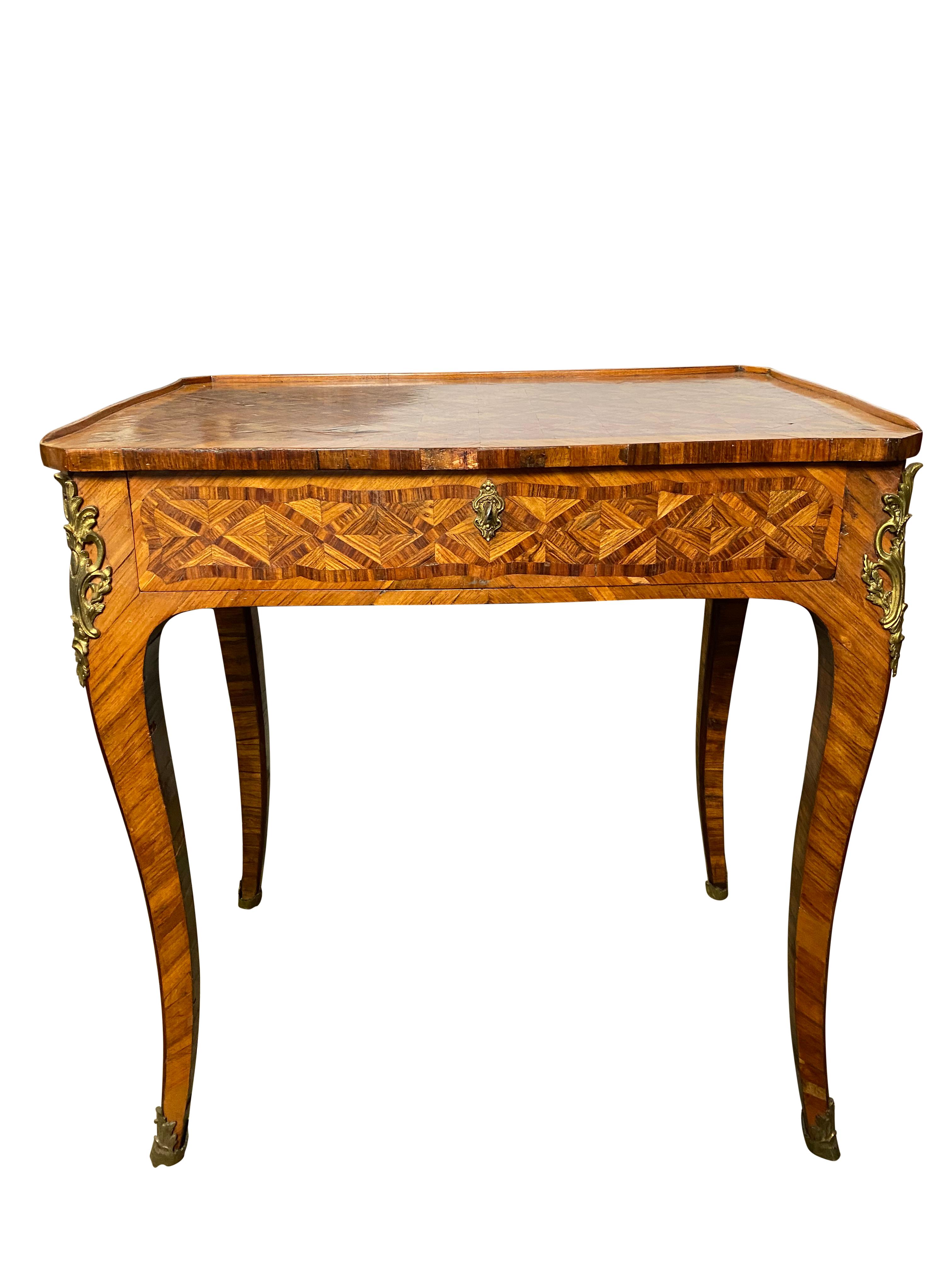 A fine French marquetry inlaid kingwood table with well-figured top and lock and key drawer. Mutiple 
differential grain patterns throughout the table and lavished in metallic embellishments on the lateral sides of each leg. 

Dimensions (cm)
H