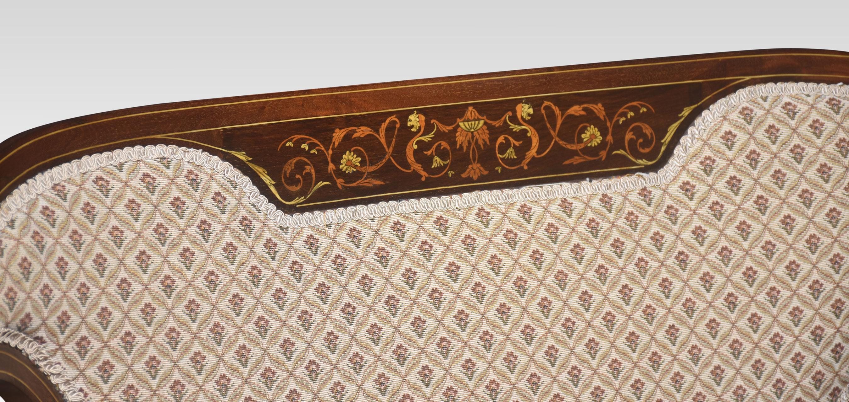 Marquetry inlaid settee. Having a shaped back with fine marquetry and pen-work inlaid panel above the central padded back, flanked by pierced fretwork panels, with open arms and a padded seat. Supported on slender tapering