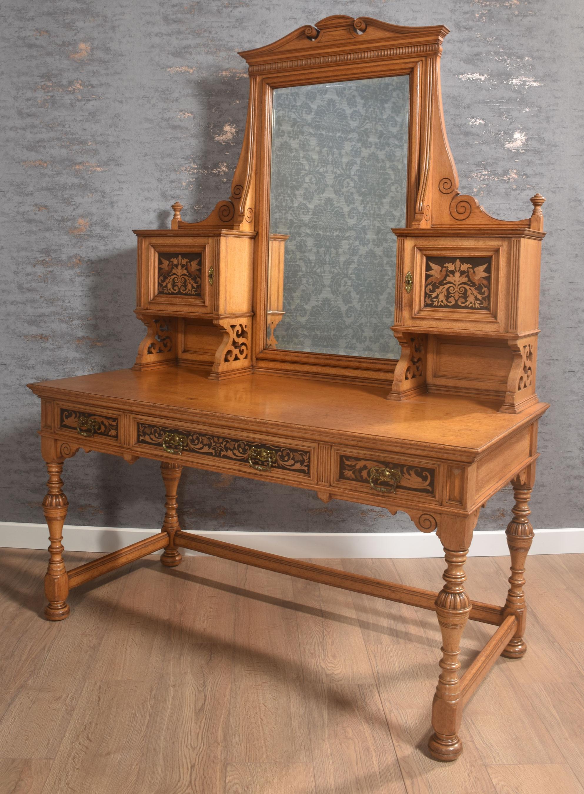 Tavolino da toilette in quercia intarsiata di Gillows of Lancaster, con specchio centrale regolabile sostenuto da una cornice architettonica e affiancato da ante di armadietti ebanizzati intarsiati. Al piano rettangolare sovrastante una disposizione