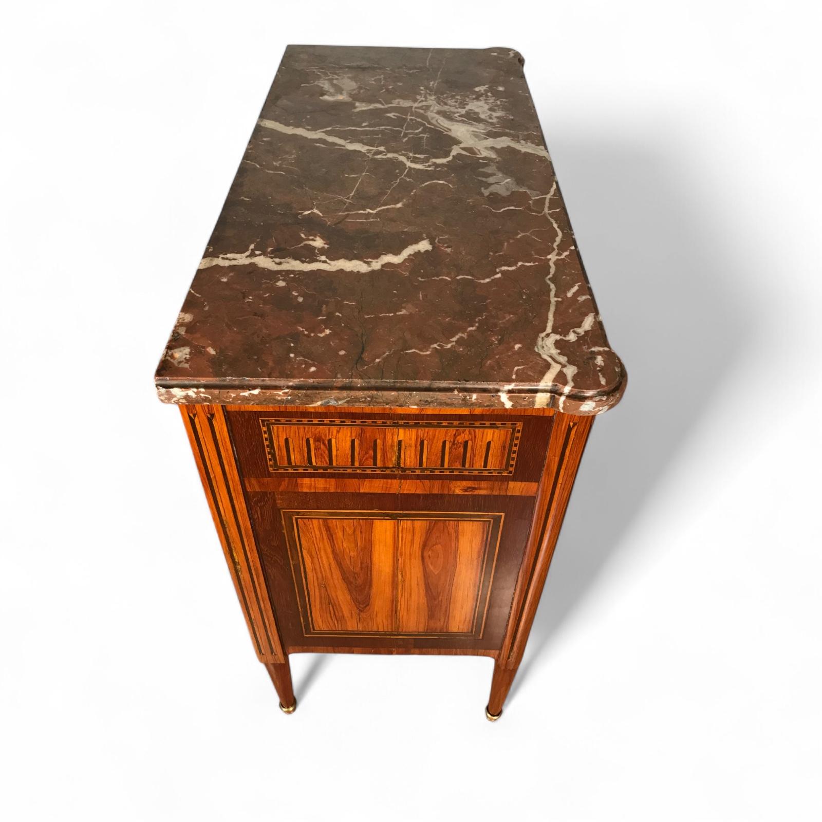 Cassettone Luigi XVI intarsiato, Francia, 1770 circa
Questa raffinata cassettiera Luigi XVI intarsiata è originaria della Francia e risale al 1770 circa, durante il periodo di transizione tra l'ornato stile Luigi XV e il sobrio neoclassicismo di