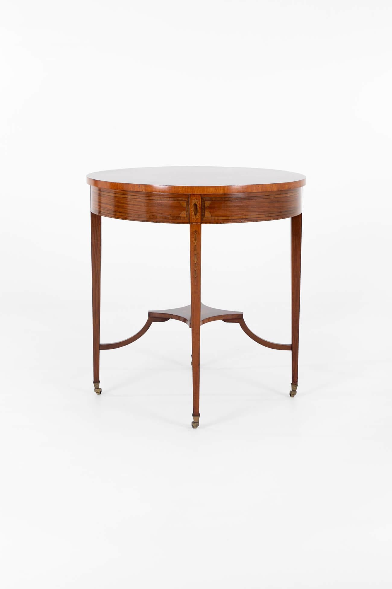 An Edwardian mahogany and marquetry occasional table with square block legs raised on original brass castors.

The legs are united by a cross stretcher with detailed marquetry inlays and conforming decoration.

The circular marquetry inlaid top is