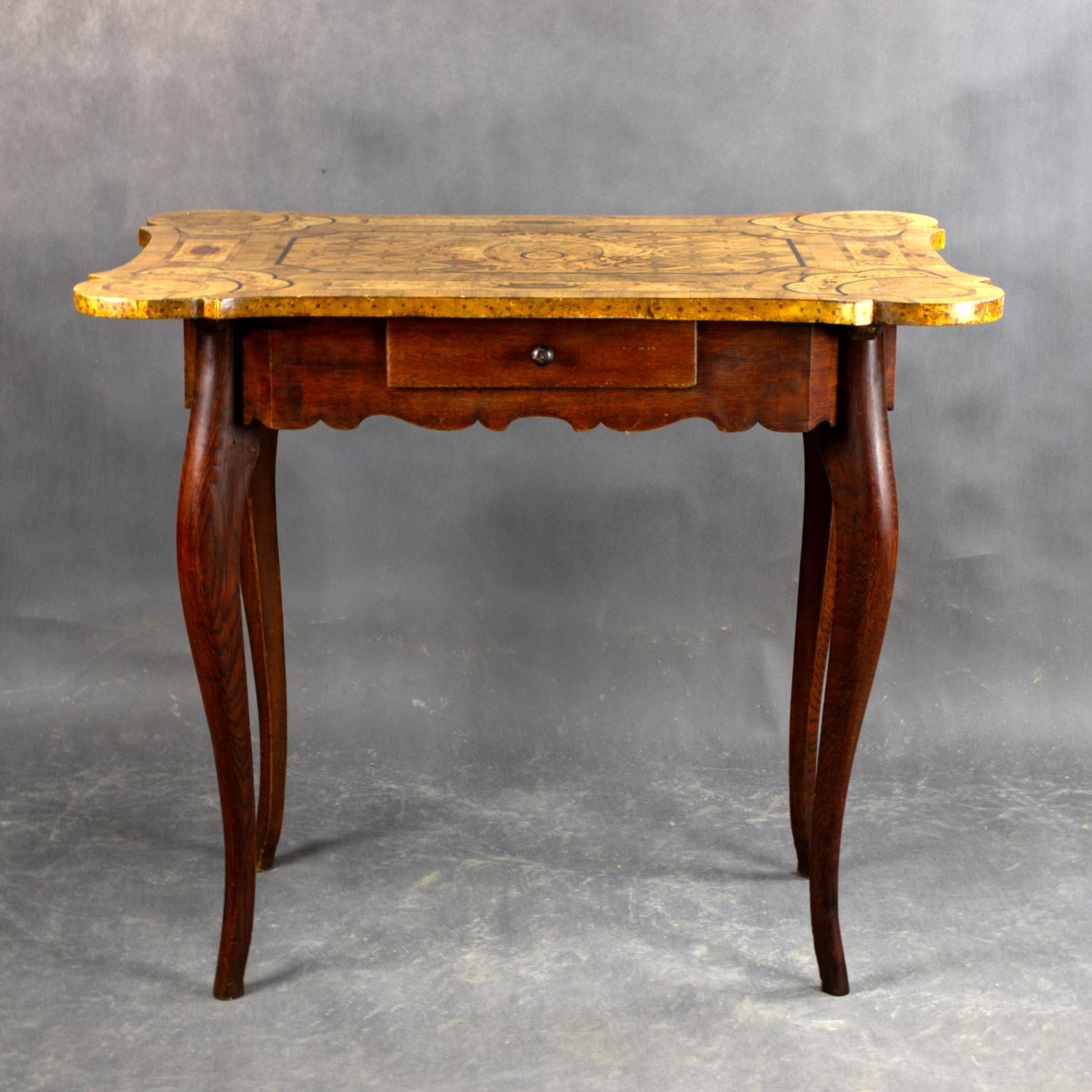 This unique rococo table is a fine example of European craftsmanship from the late 1700s of French origin. Made in the Rococo style, it features a richly detailed marquetry top with floral and geometric patterns, using various types of wood such as