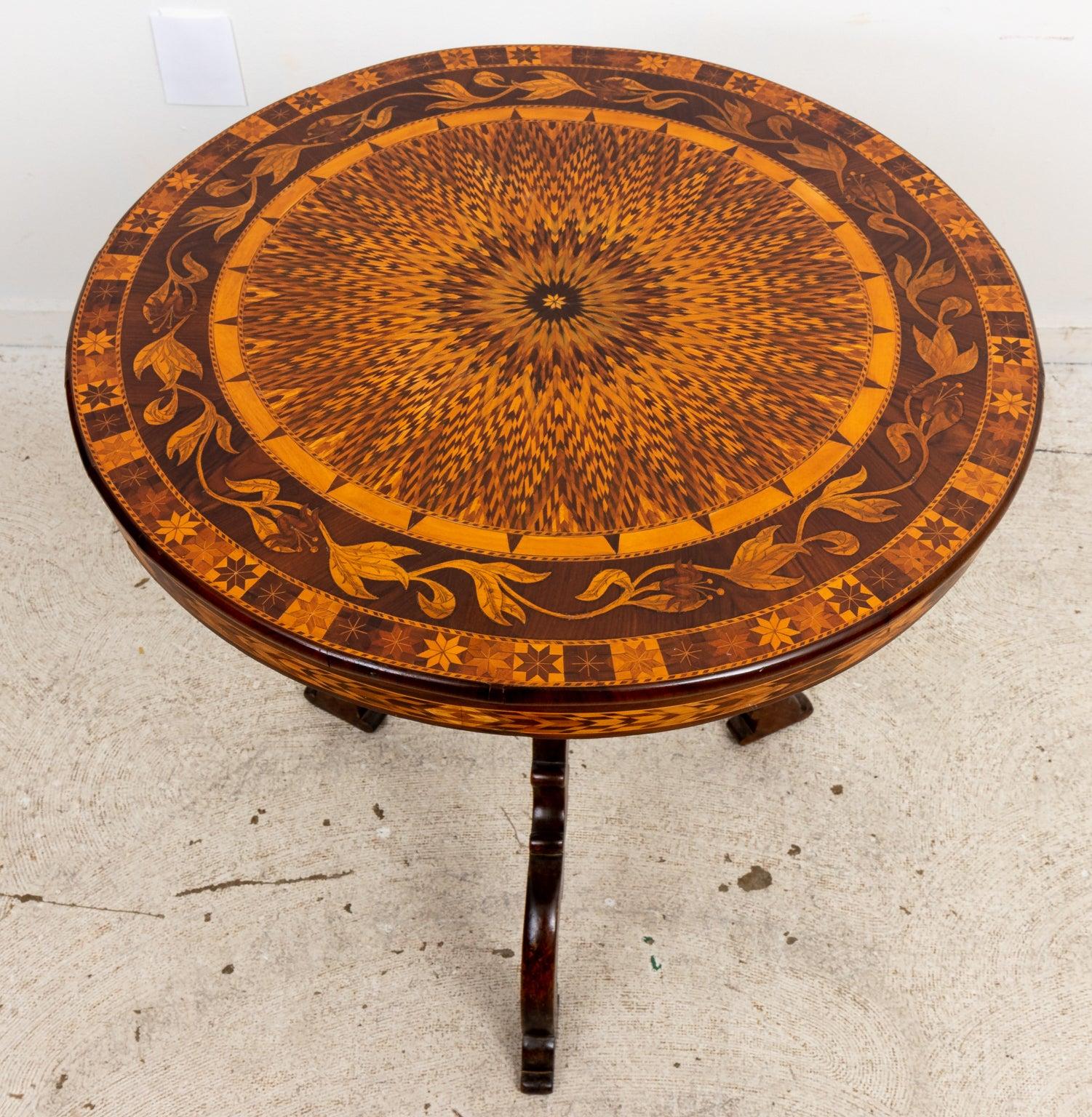 Heavily inlaid marquetry pedestal table with central starburst medallion and encircling vine banding. Please note of wear consistent with age.