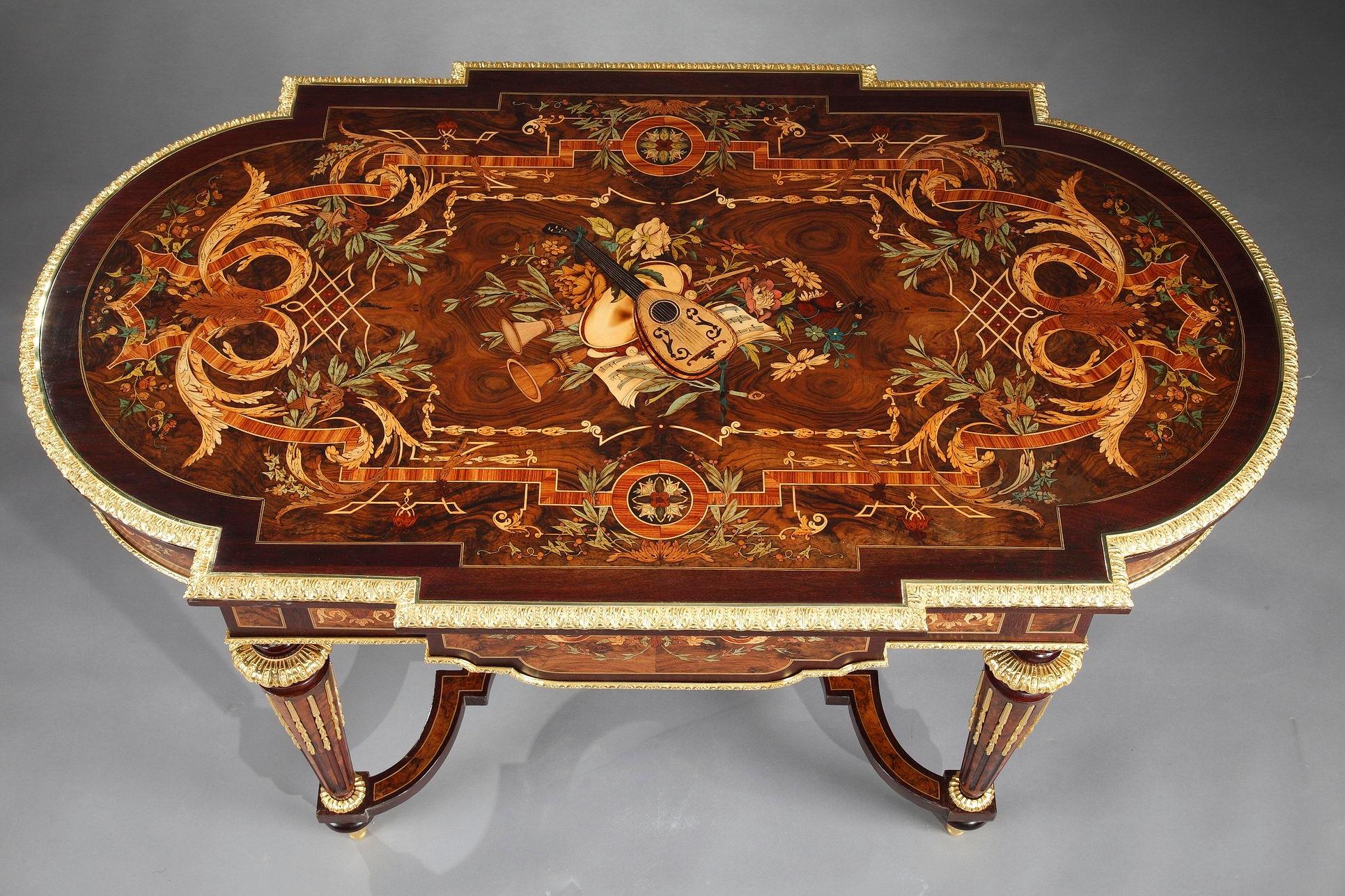 Sumptuous table in Louis XIV style, with oblong tray featuring colorful wood marquetry. The exquisit decor captures musical trophie framed by a border of foliated rinceau, interlace and floral pattern. It opens by a large front drawer, and rests on