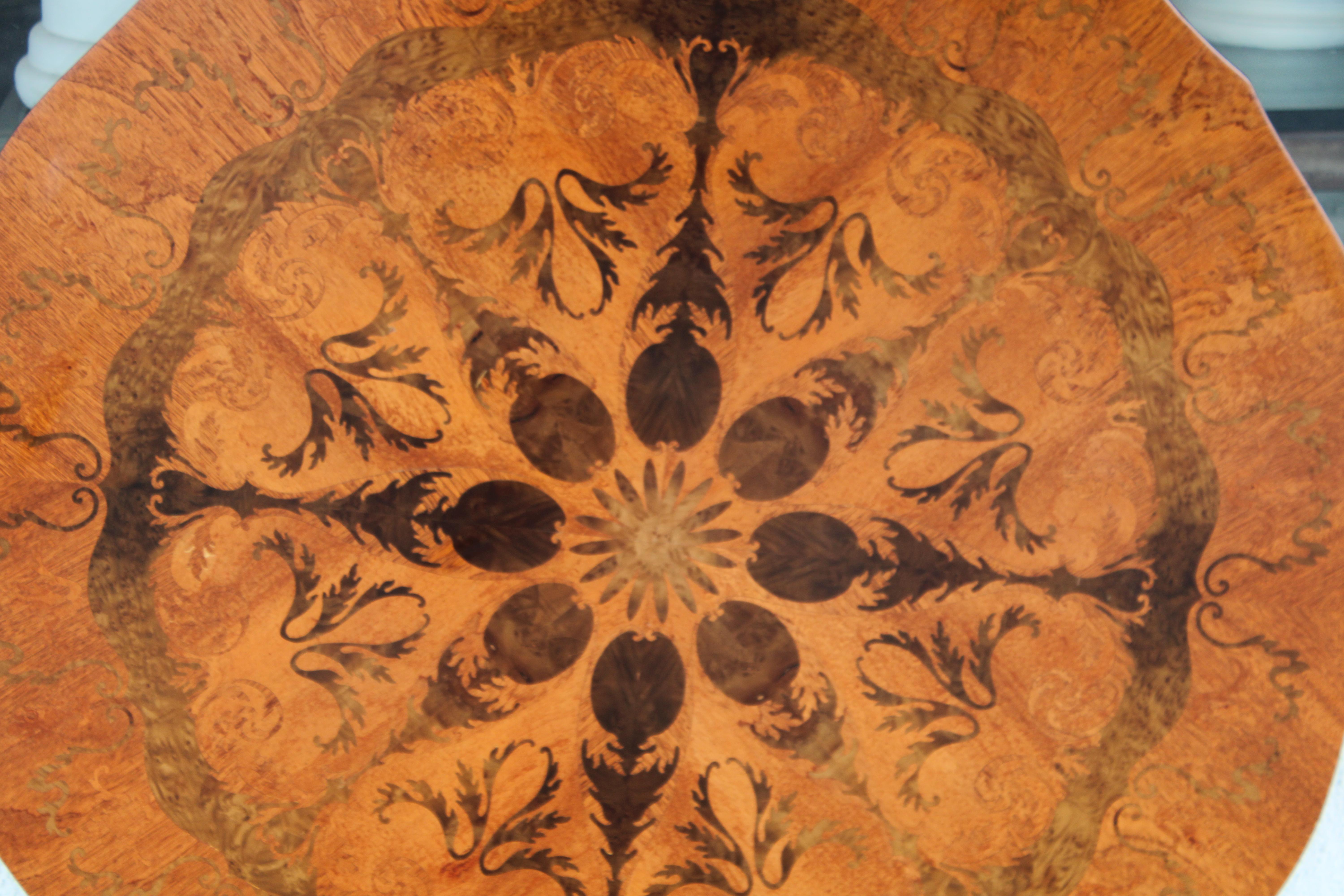 Incredible marquetry table top in kaleidoscopic mirroring patterns, using various hardwoods.  Table top consists of eight sections, forming a circular whole. Old world intricate marquetry work is superb and unequalled.   Table is 44