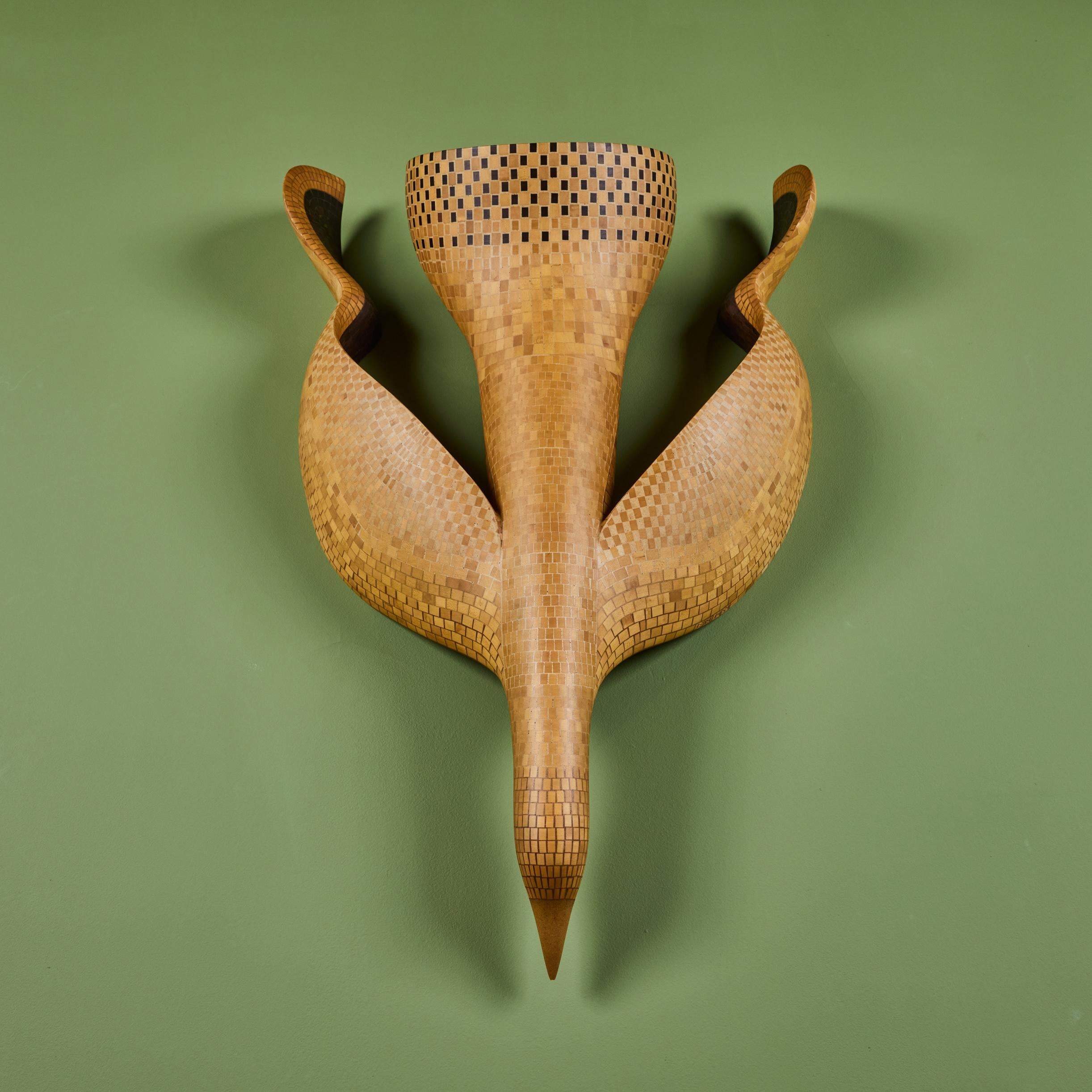 Wood marquetry wall mounted albatross sculpture by American artist Emile Norman. The sculpture features geometric square and rectangular strips of varying hardwood veneers. The sculpture can be mounted to face up or down. Marked on EN