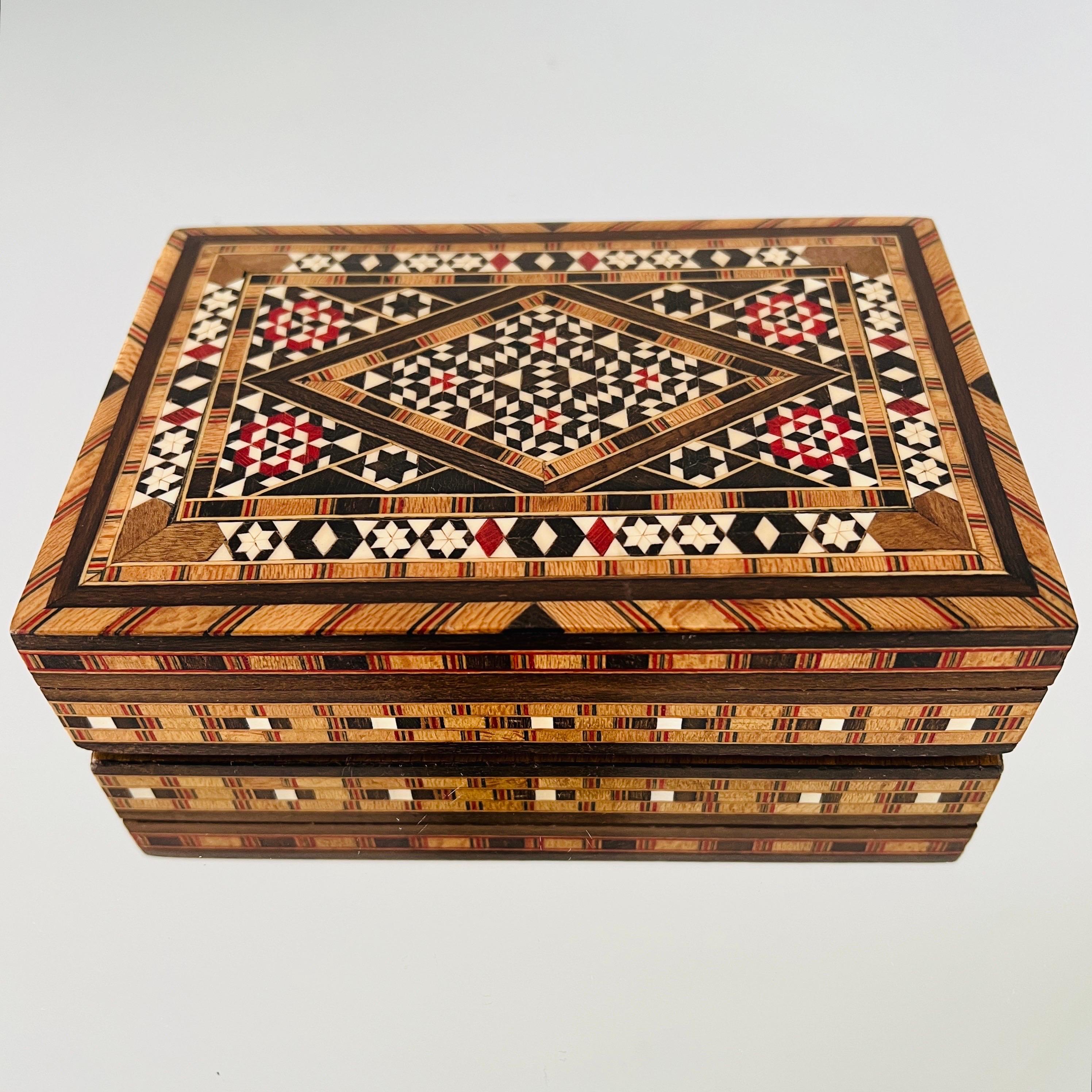 Exquisite handcrafted Khatam wood box with micro mosaic marquetry design, an Ancient Persian technique of inlaying.  Moorish style box features geometric inlays of wood and bone. Artisanal craftsmanship with hinged lid and interior lined in red