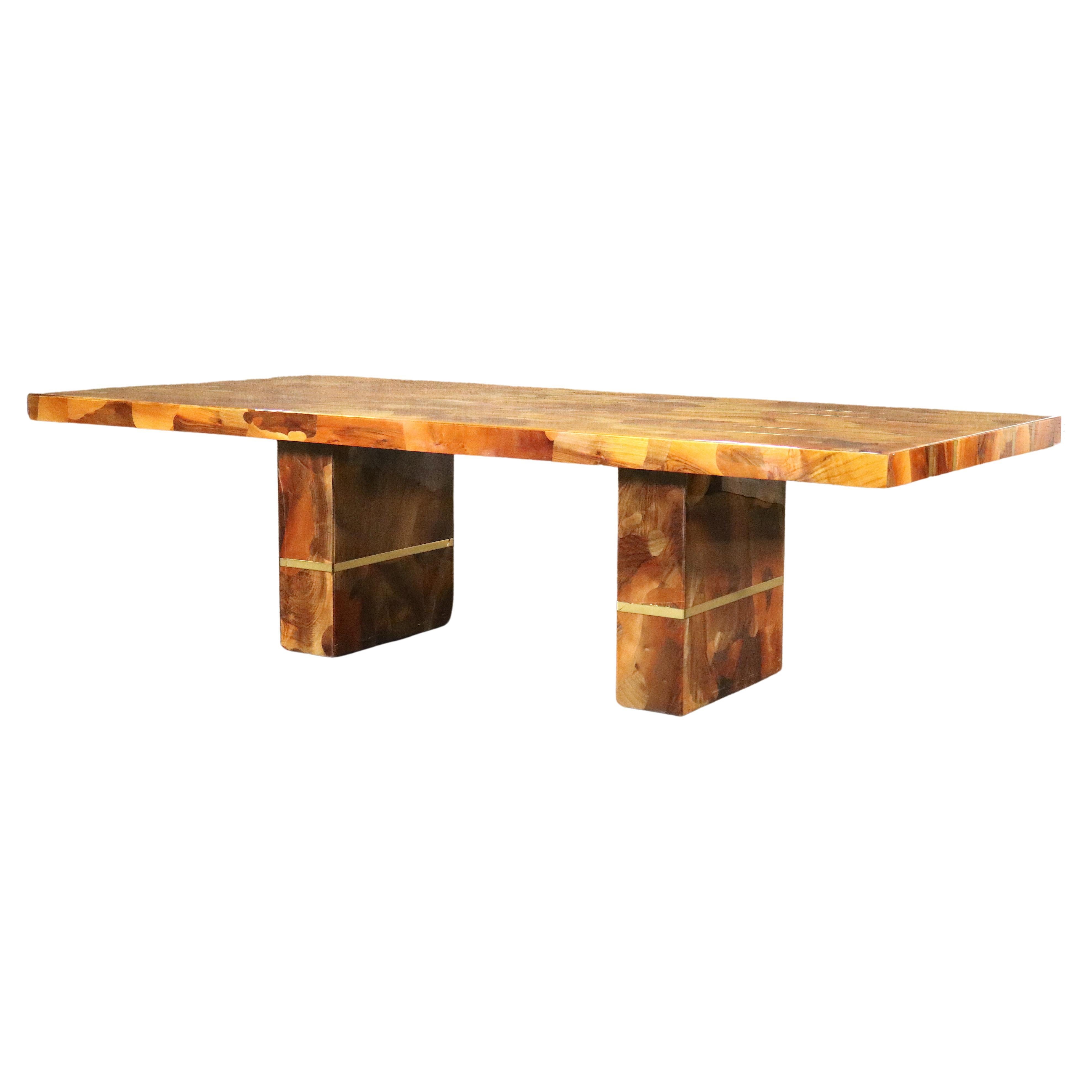 Cette table de salle à manger en bois de style moderne du milieu du siècle est ornée d'une incrustation en laiton et d'une magnifique façade en bois mosaïque. Il repose sur deux solides pieds piédestaux, également incrustés de lignes en