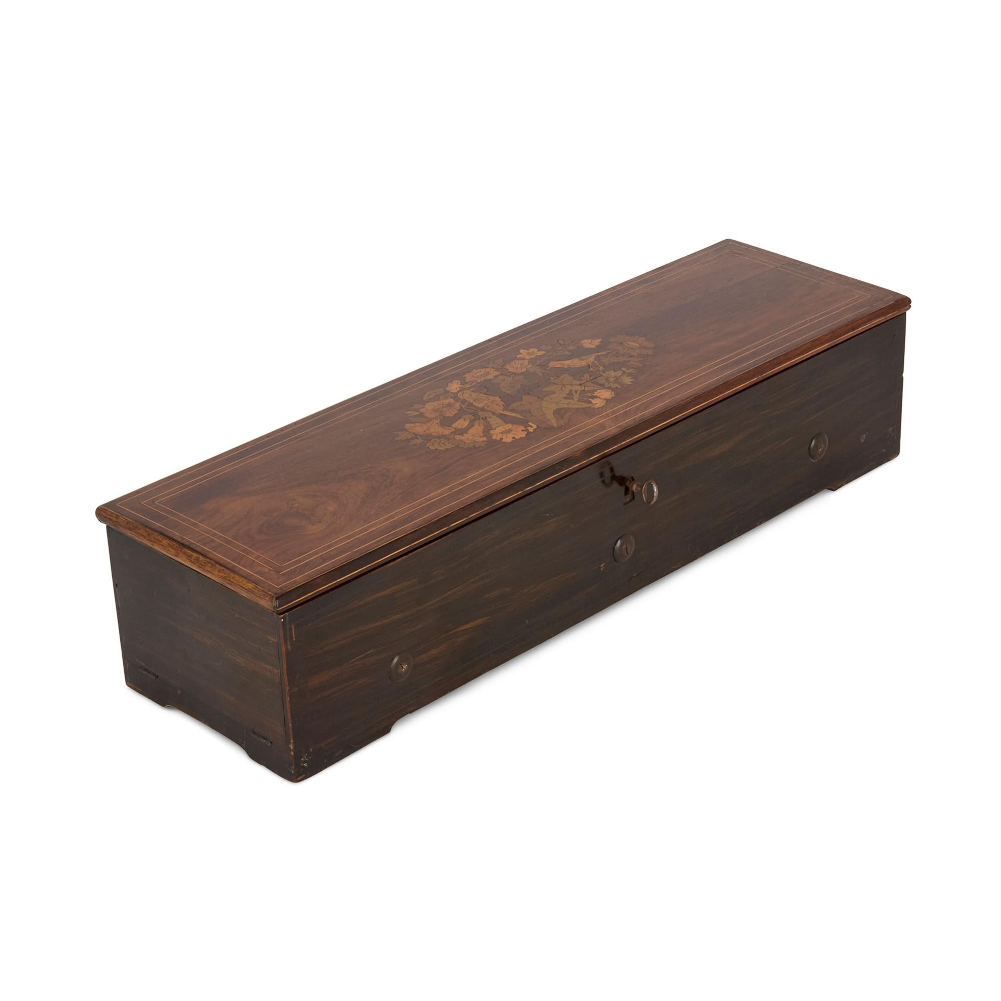 Caja de música de marquetería de madera de Nicole Frères
Suiza, finales del siglo XIX
Altura 14 cm, anchura 64 cm, profundidad 19 cm

Esta elegante caja de música de madera es un buen ejemplo de la artesanía del siglo XIX, que combina belleza