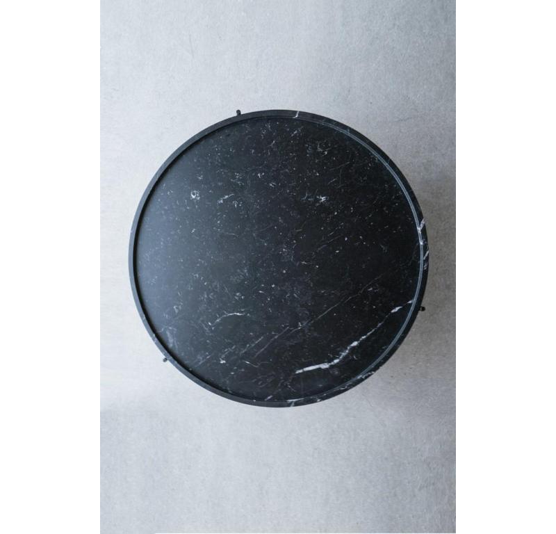 La table basse Marquina est une table basse en marbre qui canalise une sophistication monochromatique. Le plateau en marbre Nero Marquina adouci, avec ses veines blanches distinctives sur fond sombre, présente un bord empilé qui crée un rebord