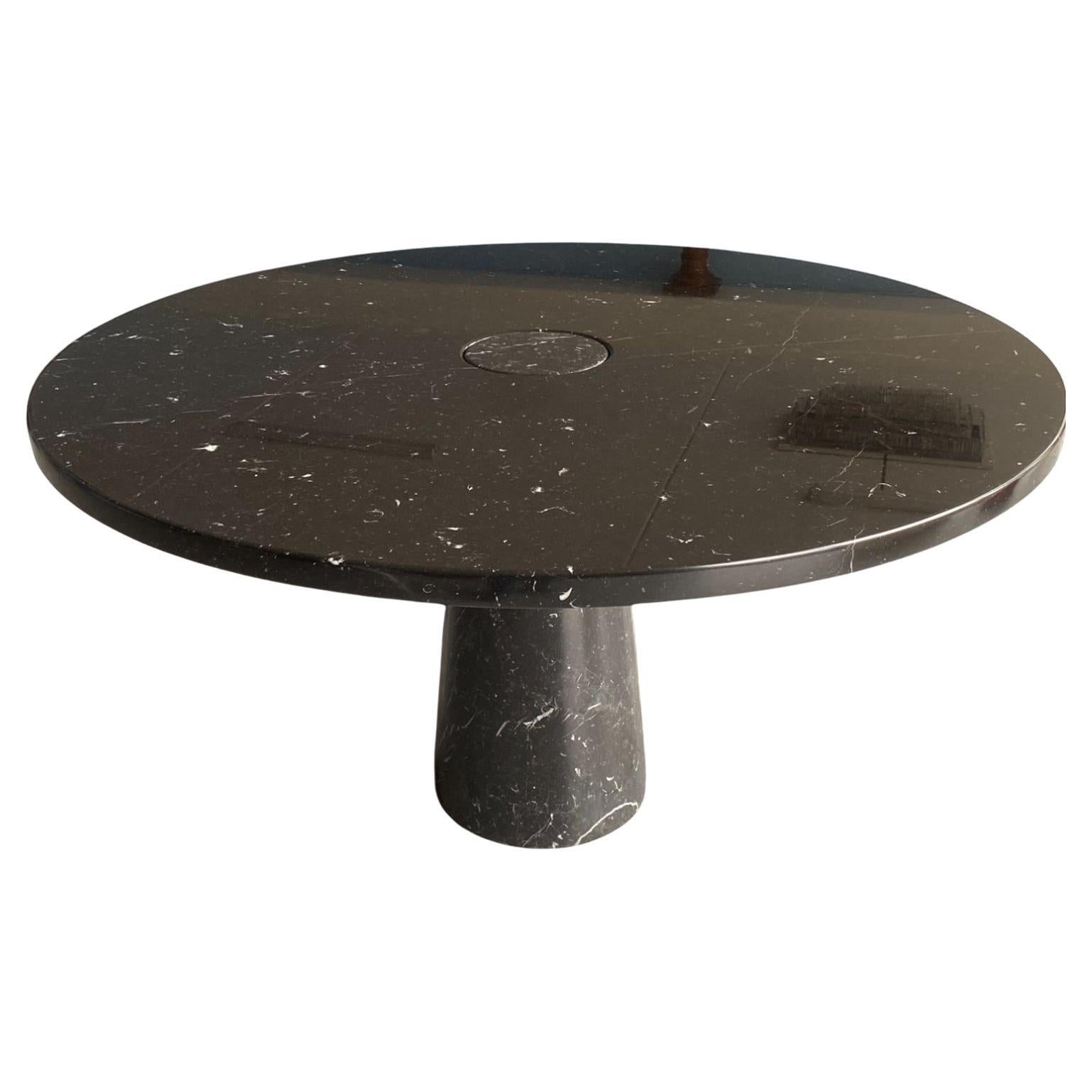 Designed by Angelo Mangiarotti for Skipper from the 'Eros' series, the dining or center table in Nero Marquina or black marble features a top mounted on a conical base. This elegant organic table showcases beautiful fine veining throughout the black