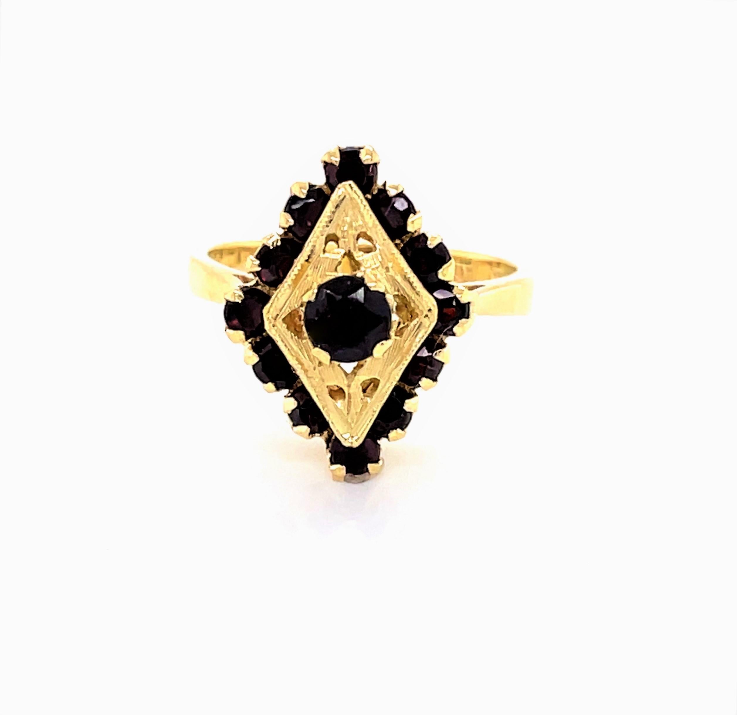 Italian made in an elegant antique style, the deep red facet cut garnet stones show warmly as set in the bright eighteen karat 18K yellow gold marquise shaped face. A raise gallery hosts the hand tooled ring head which measures 1/2 inch wide by 3/4