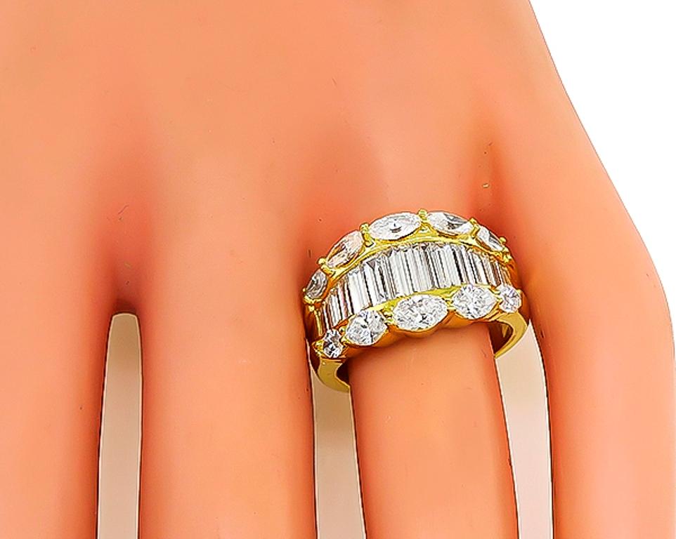 Made of 18k yellow gold, this ring is set with sparkling baguette and marquise cut diamonds that weigh 3.02ct. graded F-G color with VS clarity. The top of the ring measures 12mm by 20mm. The ring is stamped D3.02 K18 and weighs 9.3 grams.
It is