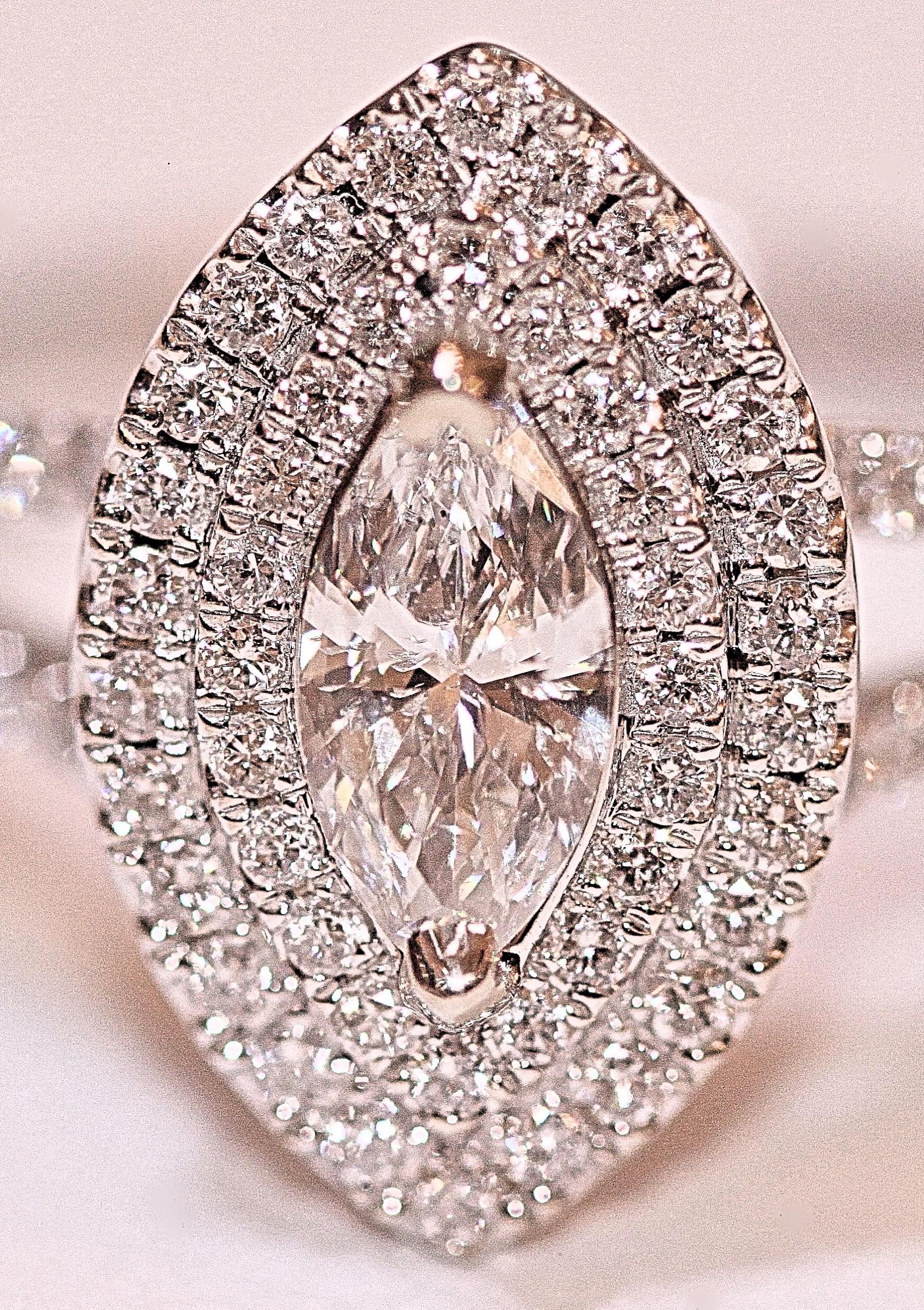Beautiful marquise cut and round brilliant cut diamond ring.  The center marquise cut diamond weighs .39 carat total.  The marquise is an SI1 in clarity and F-G in color.  The ring is a two row halo design with a split shank.  The halo and split