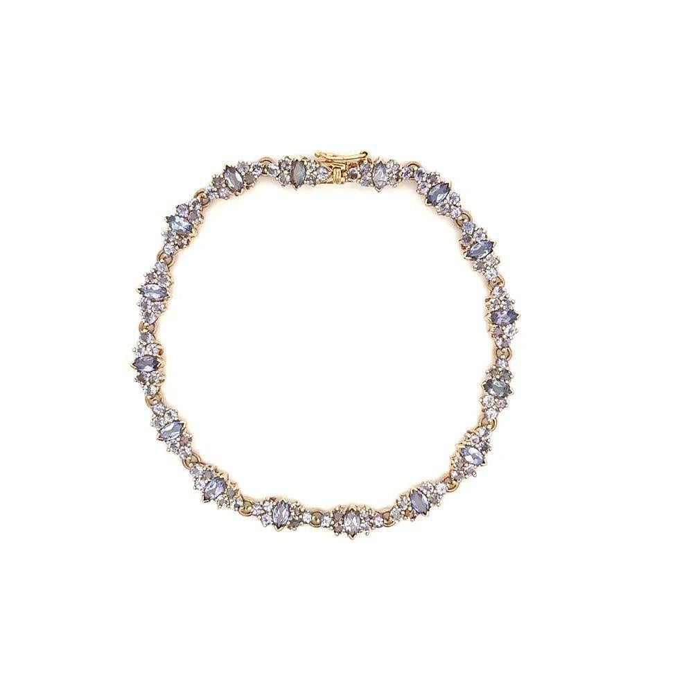 Simply Beautiful! Vintage Tanzanite Gold Cluster Link Bracelet. Hand set with Marquise and Round Tanzanite, weighing approx. 7.50tcw. Bracelet measures approx. 7.5” Long. Hand set and Hand crafted in 14K Yellow Gold. Chic and Classic and so easy to