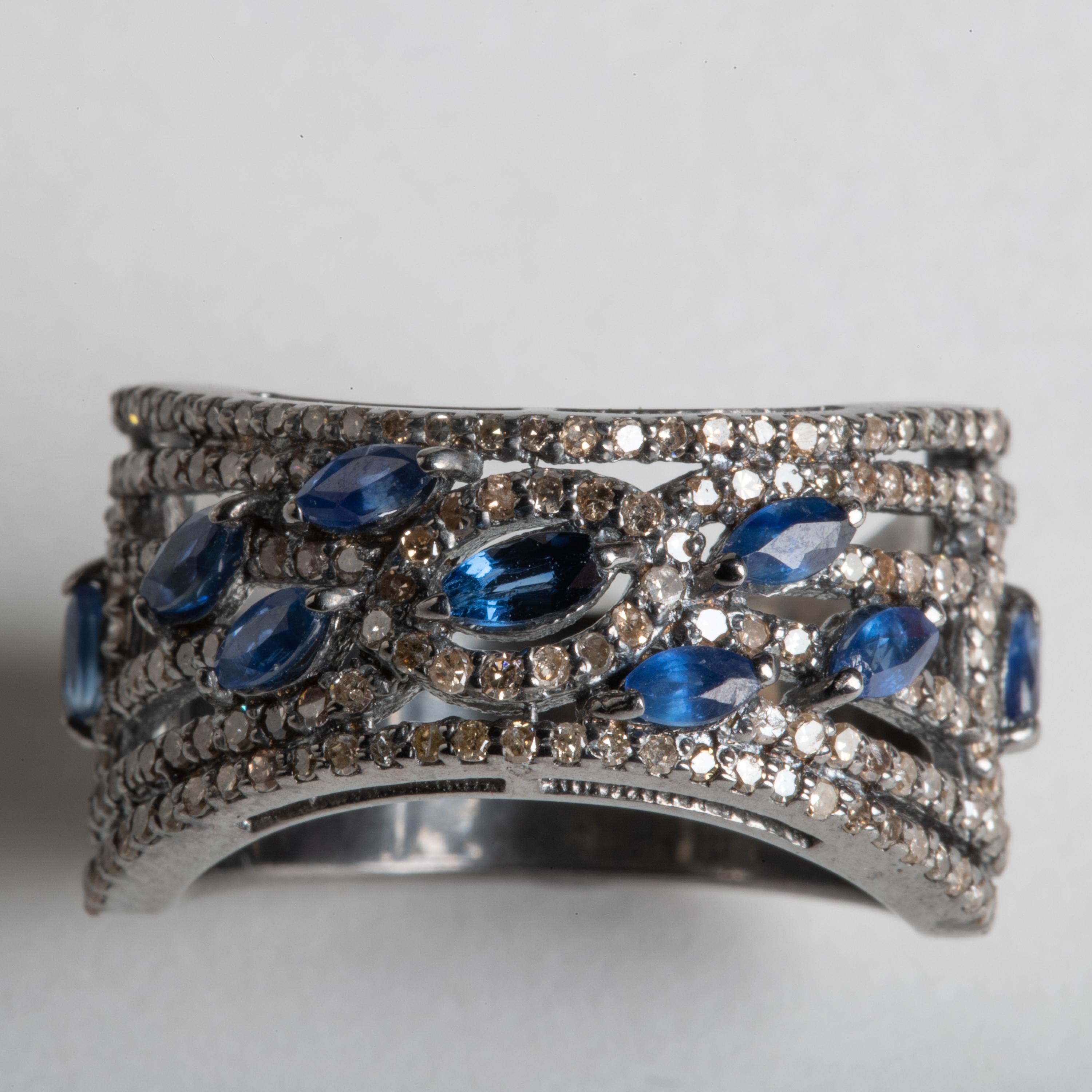 9 marquise cut blue sapphires set among round, brilliant cut, pave`-set diamonds.  In an oxidized sterling silver.  Carat weight of sapphires total 1 carat; diamonds are .99 carats.  Ring size is 8.

The fine jewelry collection is sourced, designed
