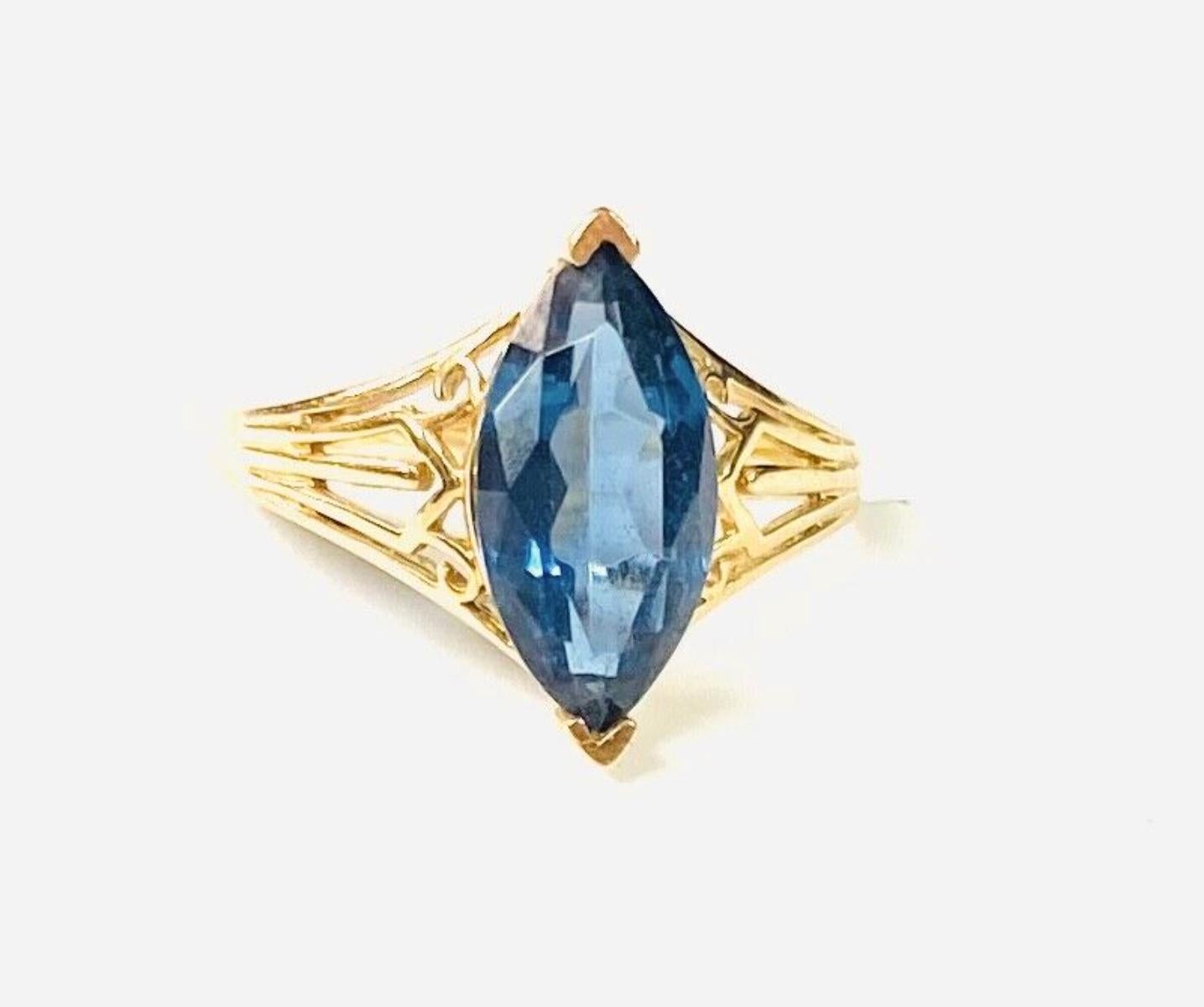 14k yellow gold marquise blue topaz ring, 3.10 Grams TW. The dimensions are approximately 14 mm x 7 mm. Approximately 3 carats. Marked 14k. Approximate size 7.5.
