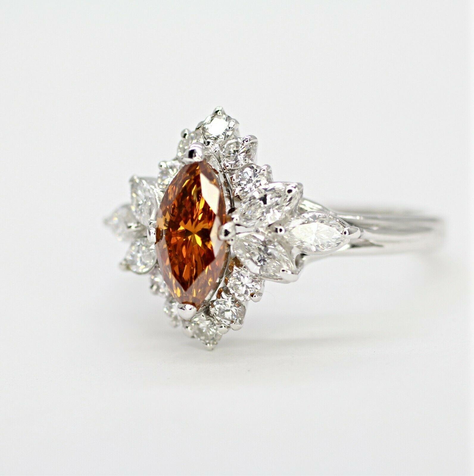  This is an antique platinum ring certified by EGLUSA. The center stone is a Marquise Brilliant Fancy orangy-brown color, SI2 in clarity, and approximately 0.65 carat weight. This ring also contains 10 pieces round brilliant cut diamonds weighing