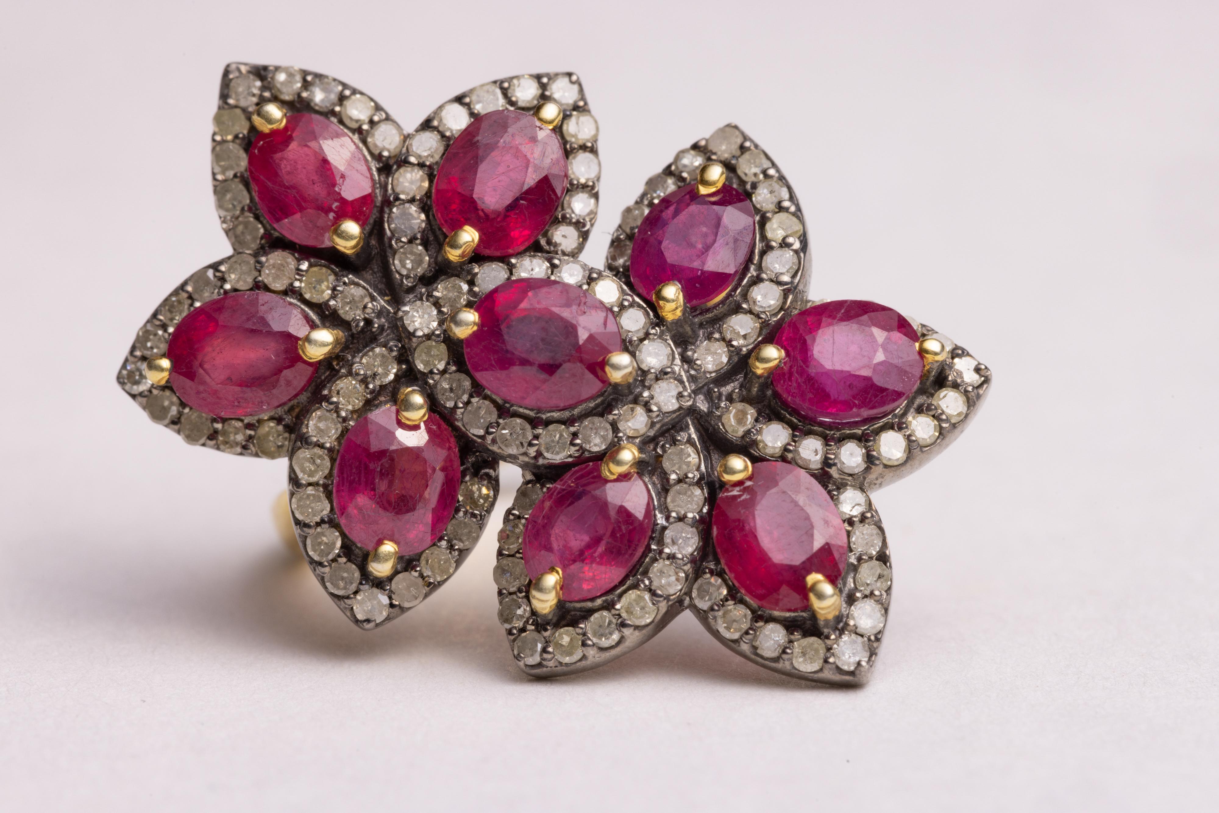 A spectacular double flower cocktail ring.  Faceted, marquise rubies bordered with pave`-set, round brilliant cut diamonds set in sterling silver.  Burmese rubies tend to be more on the pink side.  Carat weight of rubies is 5.17; diamonds total .92