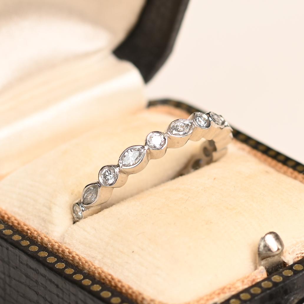 Cet exquis bracelet d'éternité présente une élégante alternance de diamants ronds de taille brillant et de diamants marquise, créant un harmonieux mélange de brillance et de sophistication. Fabriqué à la main en platine, le design offre un affichage