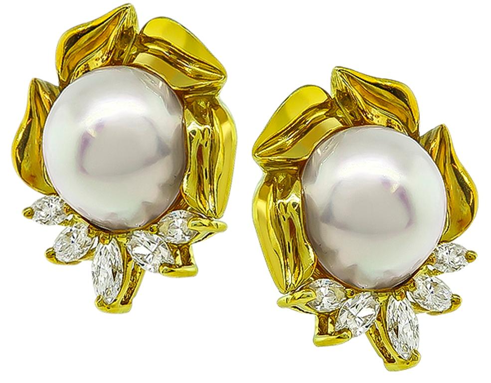 This elegant pair of 18k yellow gold earrings feature lovely mabe pearls which are accentuated by sparkling marquise cut diamonds that weigh approximately 2.50ct. graded F-G color with VS clarity. The earrings measure 26.5mm by 23mm and weigh 28