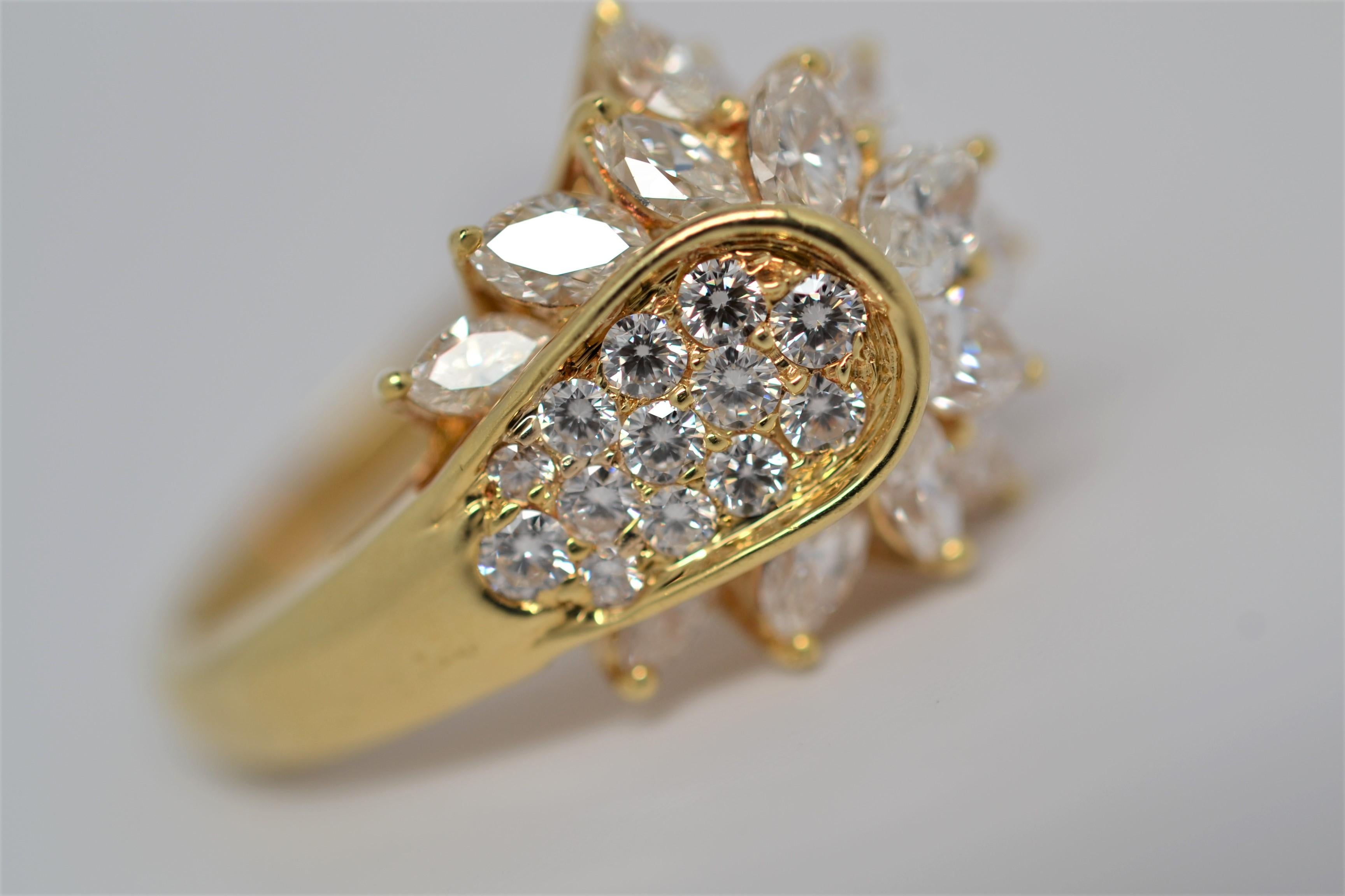This bespoke ring is a handmade design and set in 18K Yellow Gold with Marquise Cut & Round Brilliant Cut Diamonds. A statement piece with a unique layout of diamonds. There are sixteen Marquise Cut Diamonds that weigh 2.49ct total, diamond color