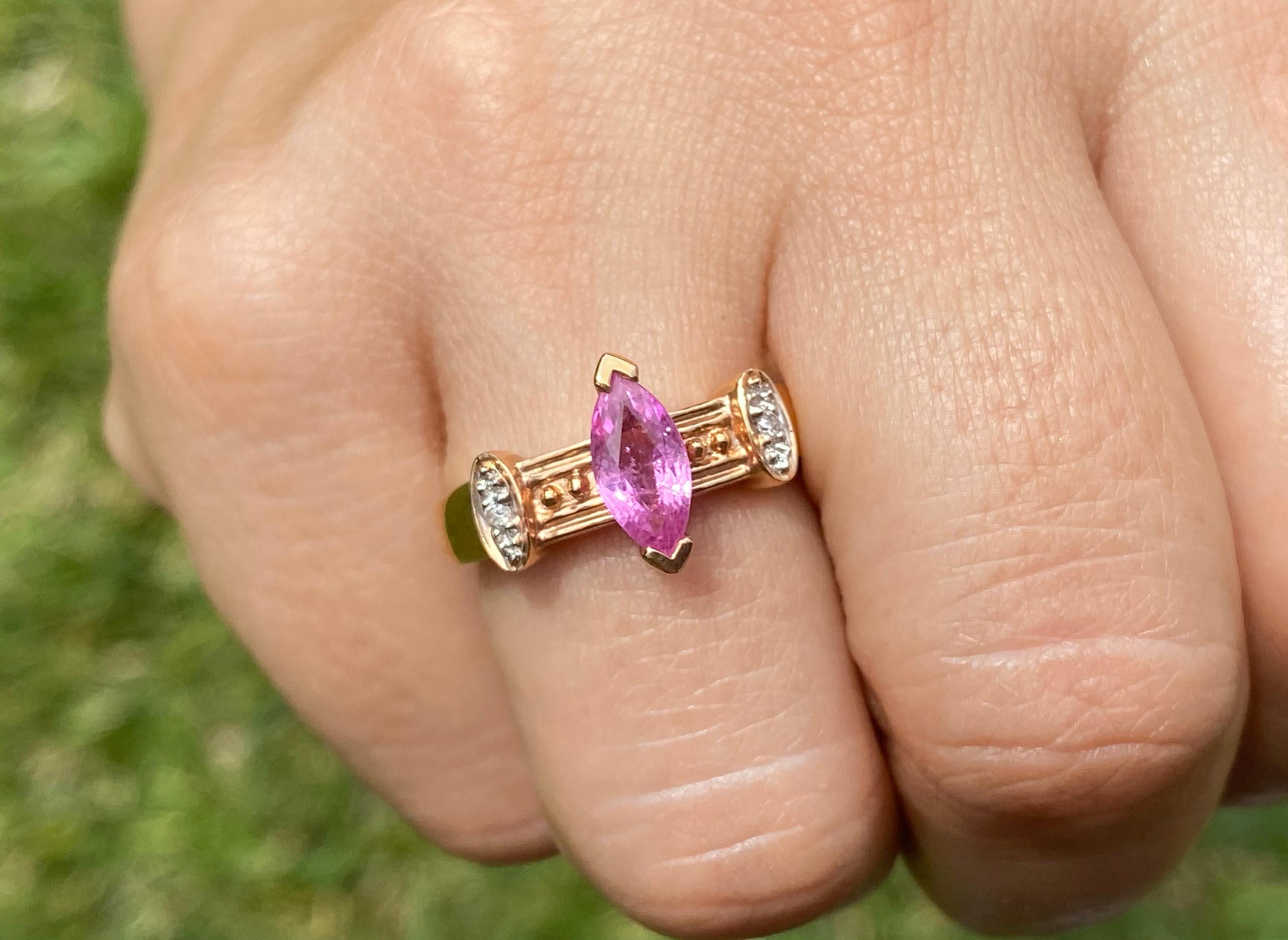 Marquise cut natural pink Sapphire adorned with natural white diamond side-stones. Gemstones are mounted in textured 14k rose gold royal retro style setting. The center stone Sapphire has flawless clarity and refracts deep bright pink color hues.