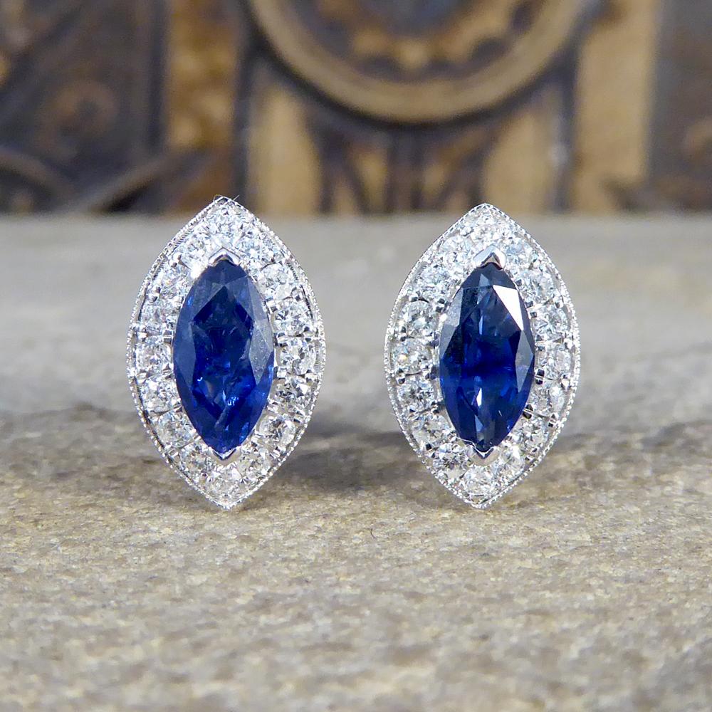 These lovely earrings feature two Marquise Cut Sapphires weighing approximately 1.00ct combined with a surround of round brilliant cut Diamonds weighing 0.32ct in total. These earrings are set in 18ct White Gold and measure approximately 11mm by