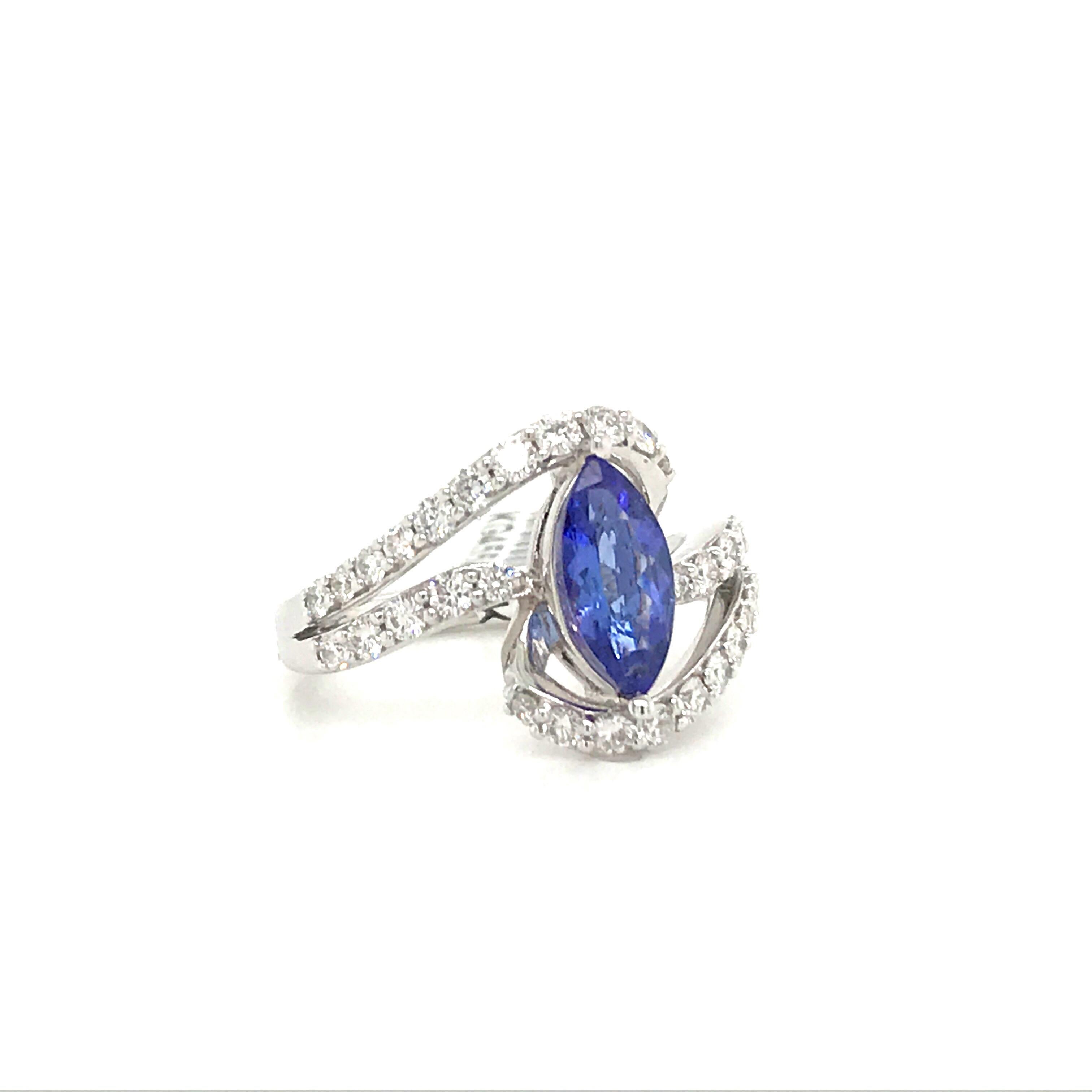 14K White gold ring featuring a marquise cut tanzanite weighing 1.19 carats flanked with round brilliants weighing 0.77 carats. 
Tanzanite: 0.64 cm * 0.97 cm
Ring: 3/4 * 3/4