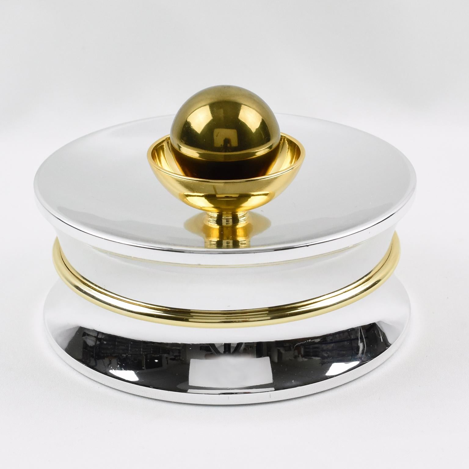 Rare elegant 1970s chrome and brass candy gift box for A La Marquise De Sevigne, the finest Paris chocolate store. Round Art-Deco-inspired modernist shape with shiny chromed metal and brass accent and large ball finial. Marked underside with the