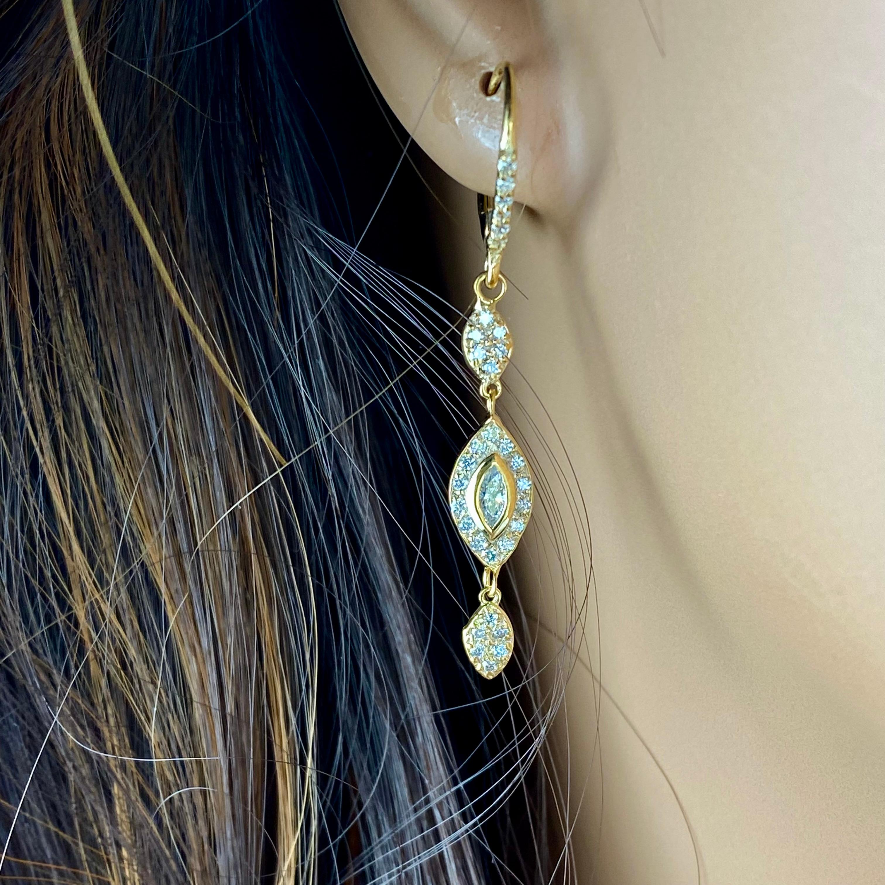 Introducing our exquisite 18 karat yellow gold hoop diamond earrings, designed to captivate with their timeless elegance and stunning craftsmanship. These earrings feature two magnificent marquise-cut diamonds, each weighing 0.25 carats, gracefully